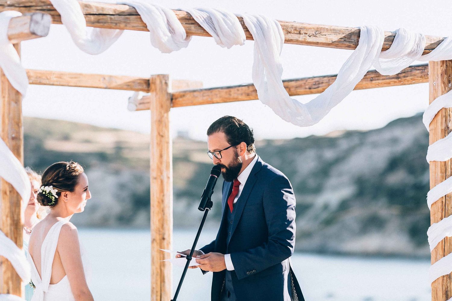Candid shot of the groom reading his handwritten vows during the ceremony