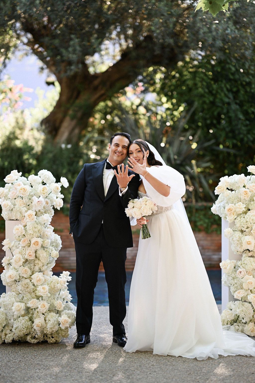 The joyful bride and groom showing their wedding rings to cheering guests right after the ceremony at the Finca del Canónigo estate.