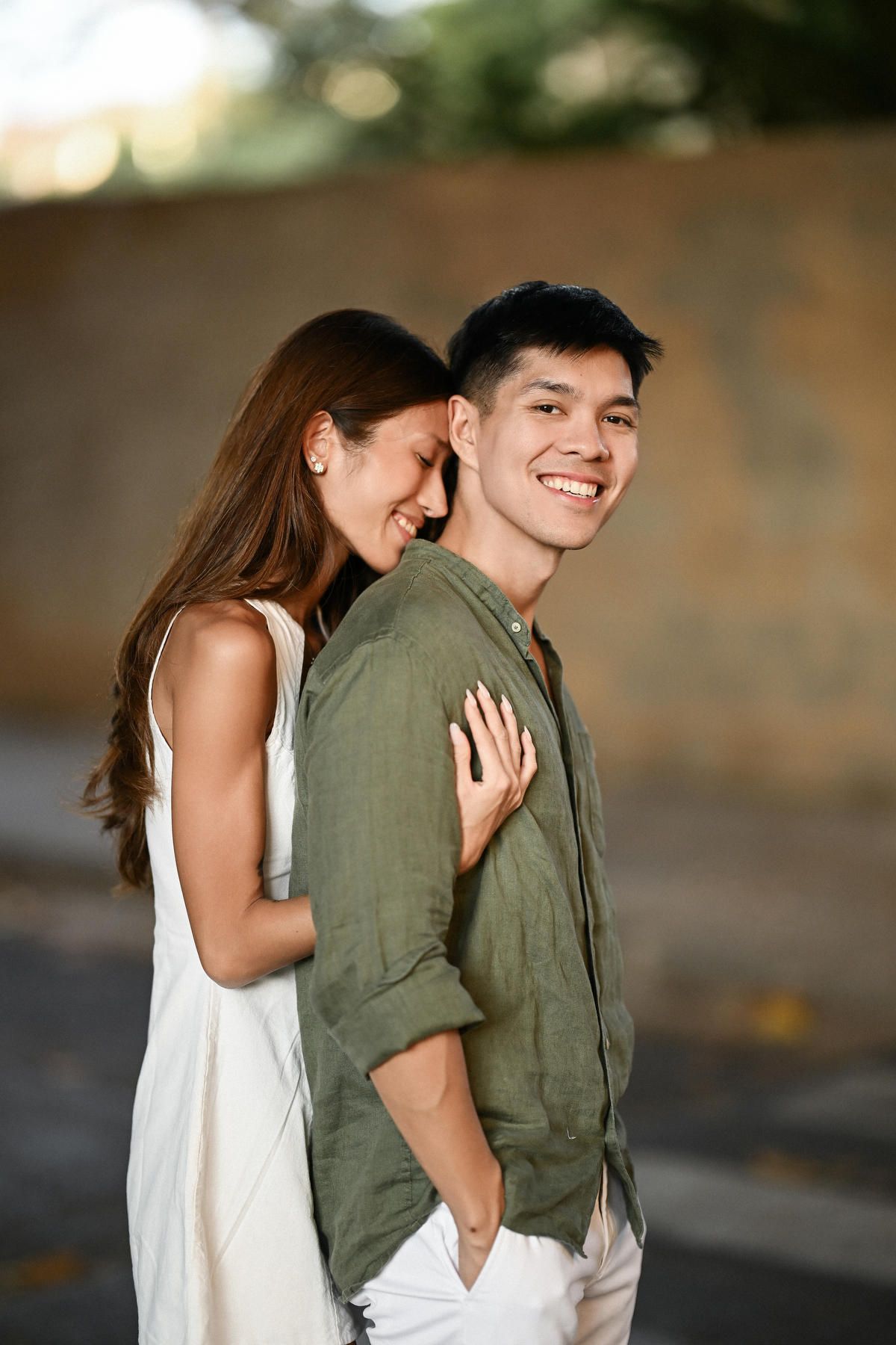 A woman lovingly hugs her partner from behind during their love story photoshoot in Valencia.