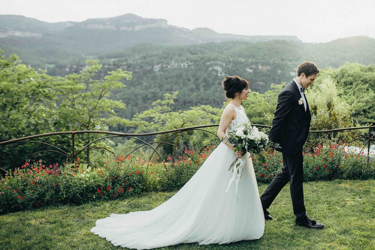 Groom and bride walking towards the banquet with scenic mountain views in Barcelona Finca