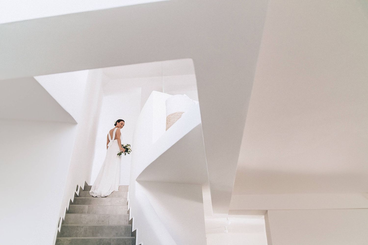 Editorial shot of the bride on modern geometric white stairs of a luxury Milos villa