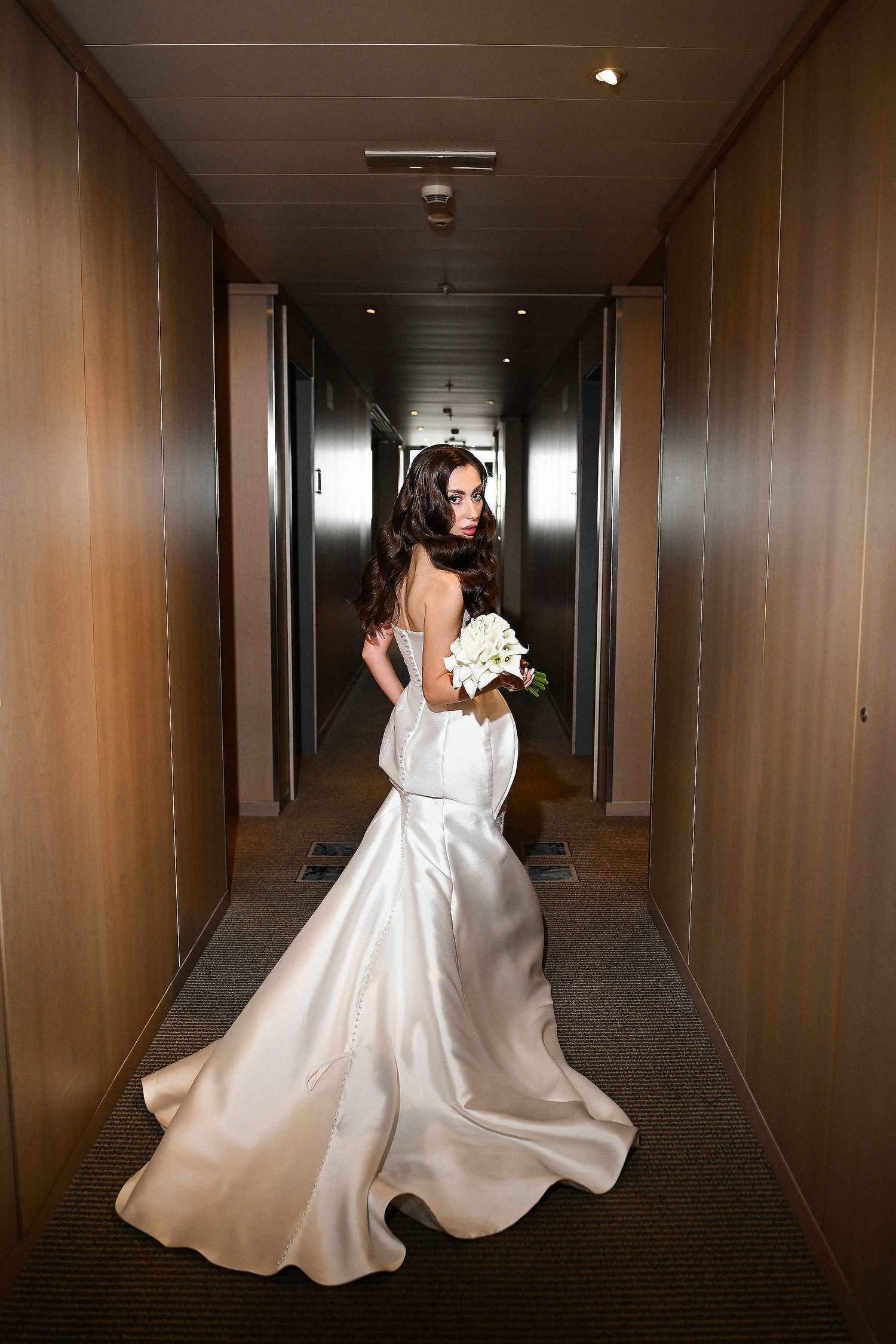 Editorial wedding photographer Spain. A dynamic, high-fashion shot of a bride in a long dress running through a luxury hotel using direct fl