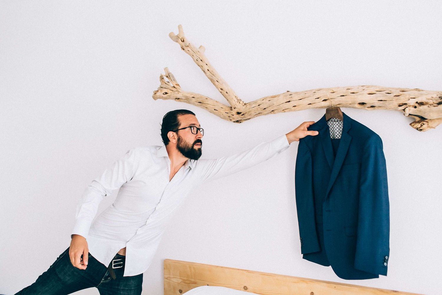 live shot of the groom putting on his suit jacket for the destination wedding
