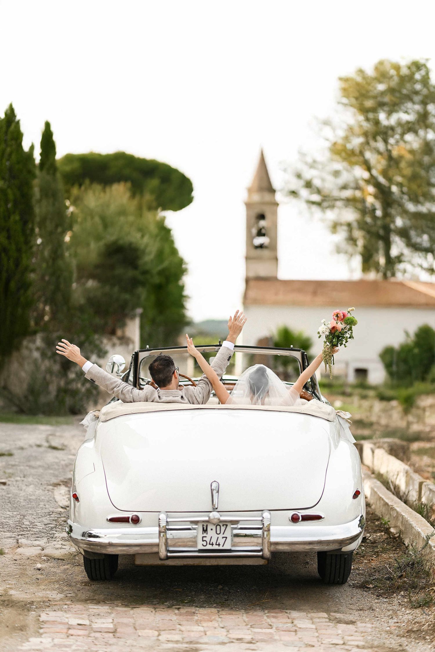 A joyful couple celebrating in a retro convertible at Villa Paula, showcasing a cinematic documentary approach to wedding photography