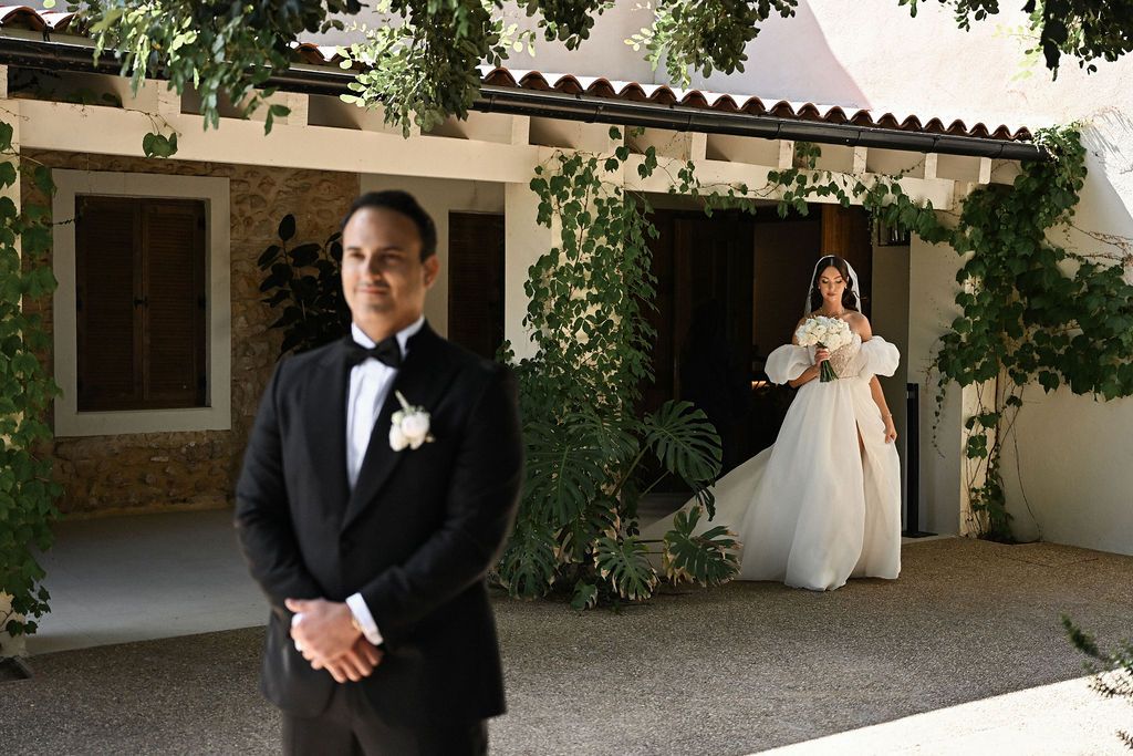 The groom waiting anxiously for his bride during an intimate and emotional first look moment in the gardens of Finca del Canónigo.