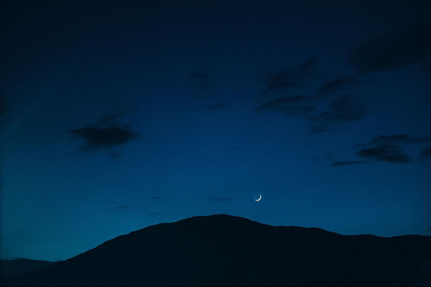 Dramatic night shot of the Milos mountains under the moonlight, creating a mystical atmosphere
