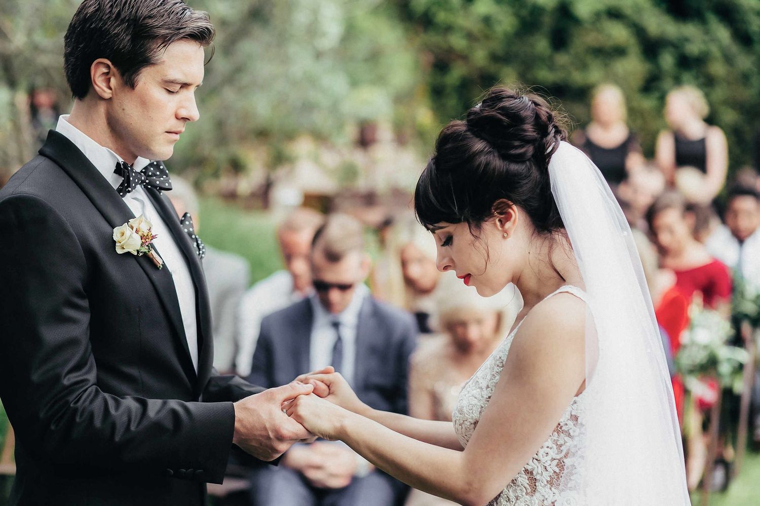An intimate moment during the ceremony: the bride and groom holding hands with eyes closed. Sincere wedding photography at a Spanish villa
