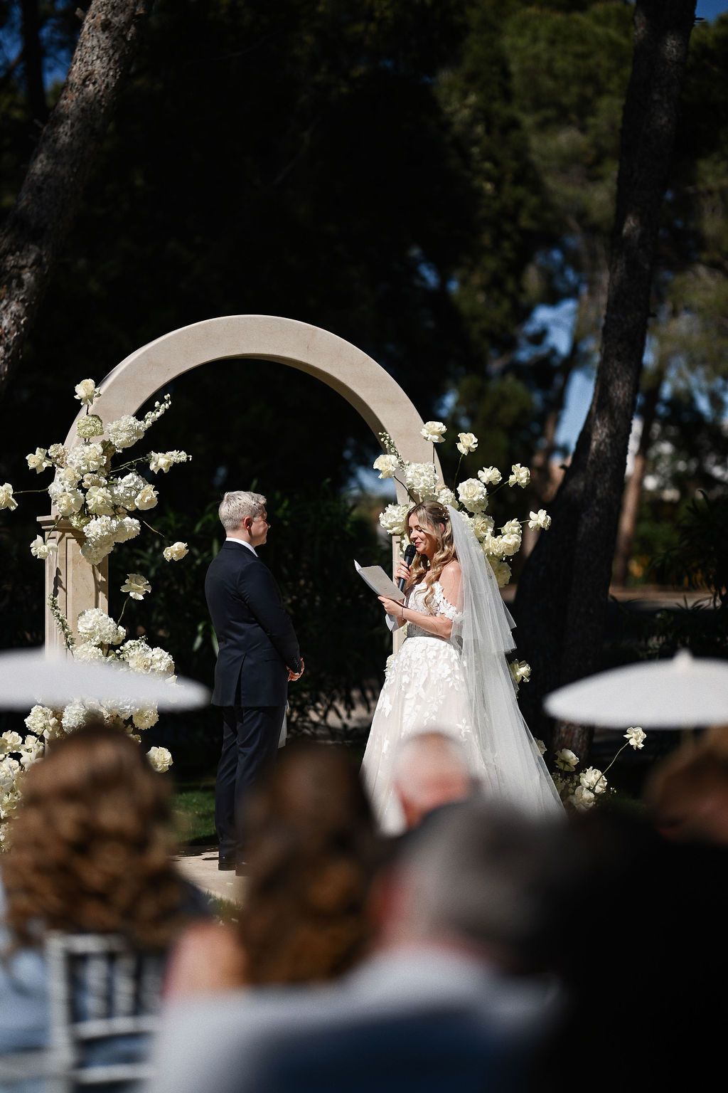 Bride reading her wedding vows to the groom in front of the guests by the stone arch at Finca El Senyoret. Benidorm photo by Darista.