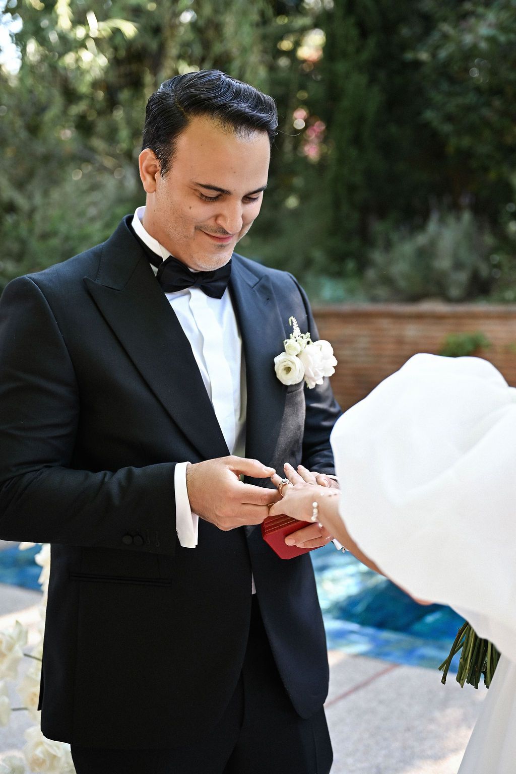 Close-up of the groom putting a gold ring on the bride's finger during the emotional exchange of vows at their Finca del Canónigo wedding.