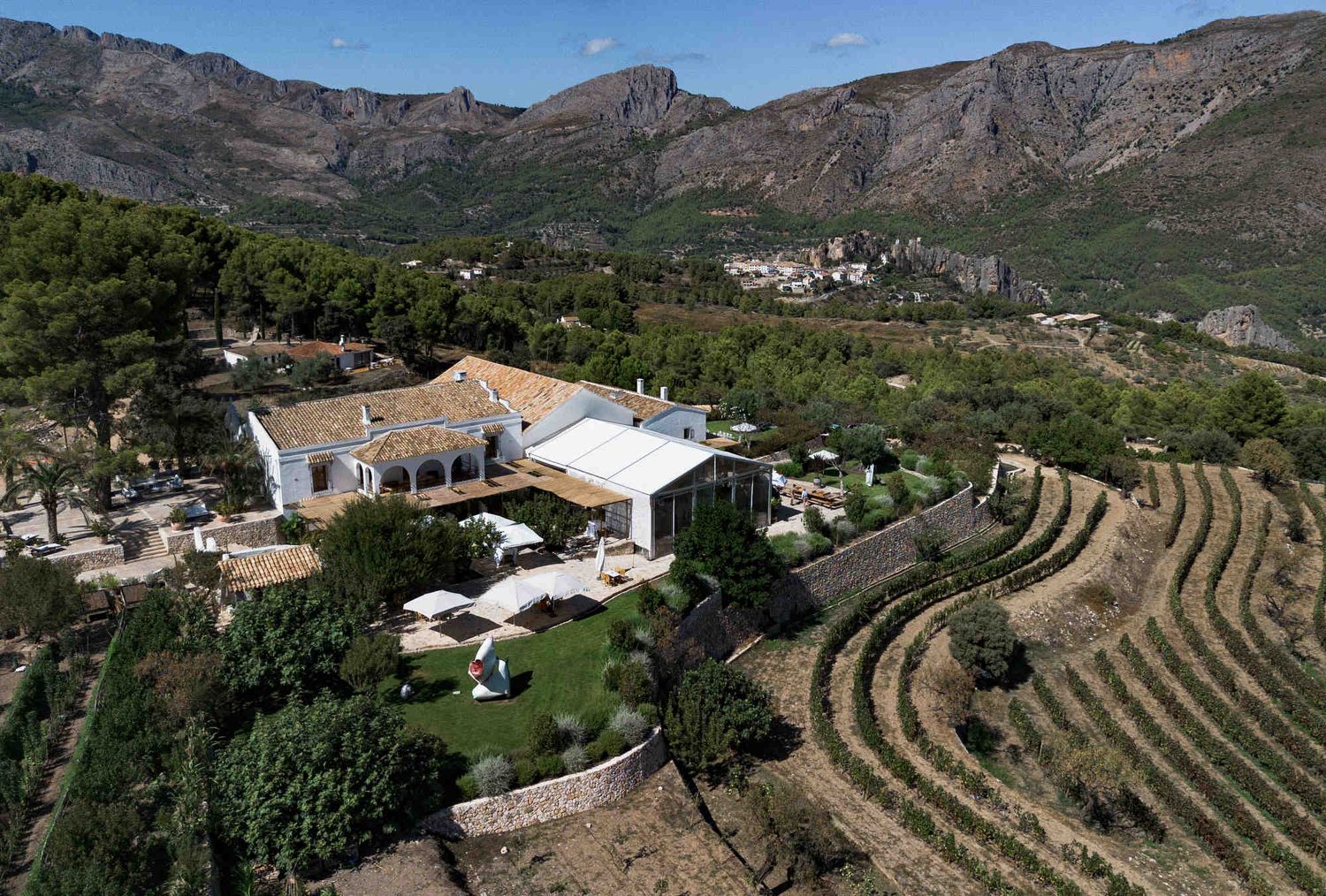 High angle shot of terraced vineyards and mountains surrounding Bodega MASOS wedding venue.