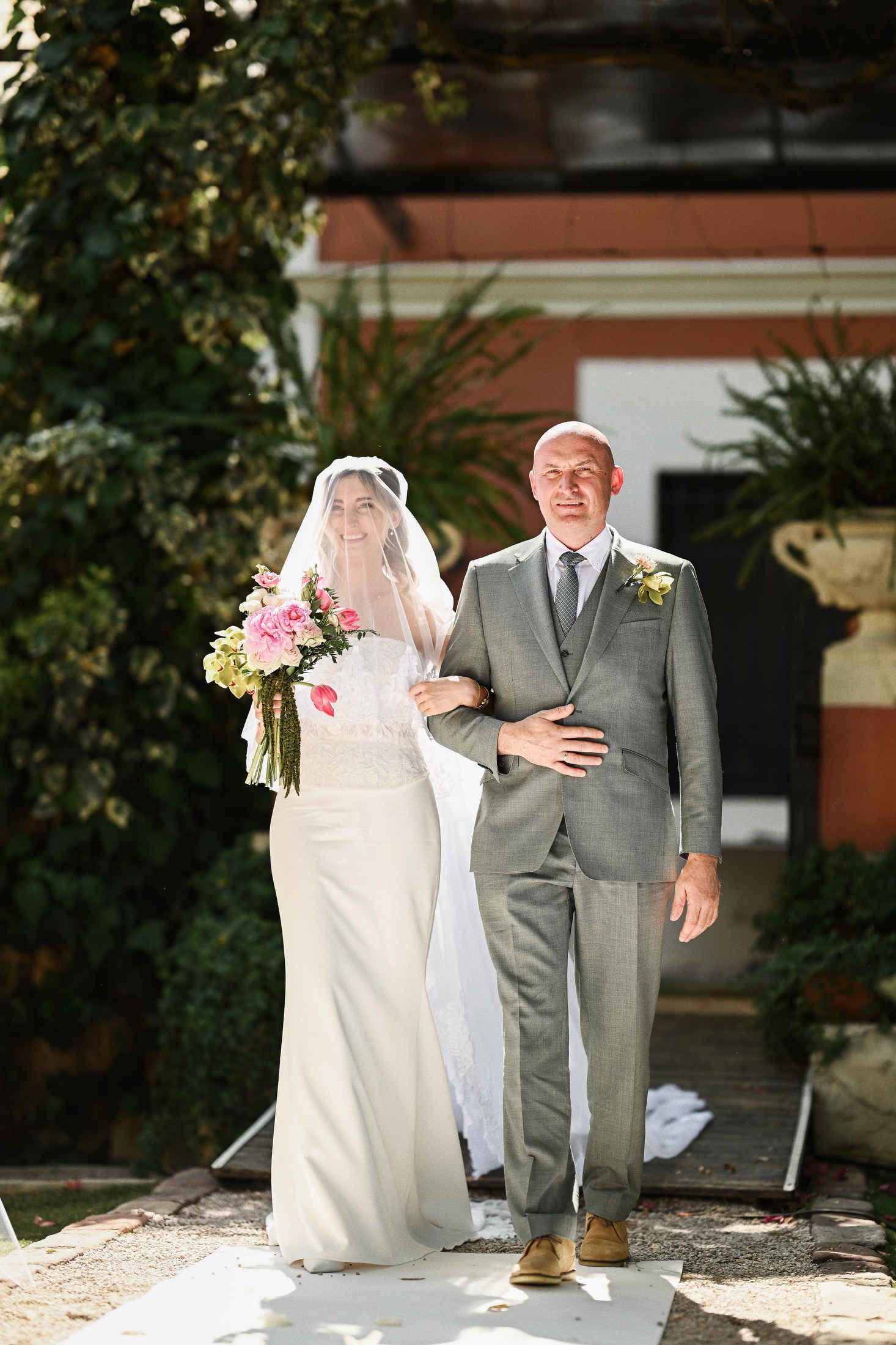 Proud father walking his beautiful daughter down the aisle during an outdoor wedding ceremony at Villa Dela in Valencia.