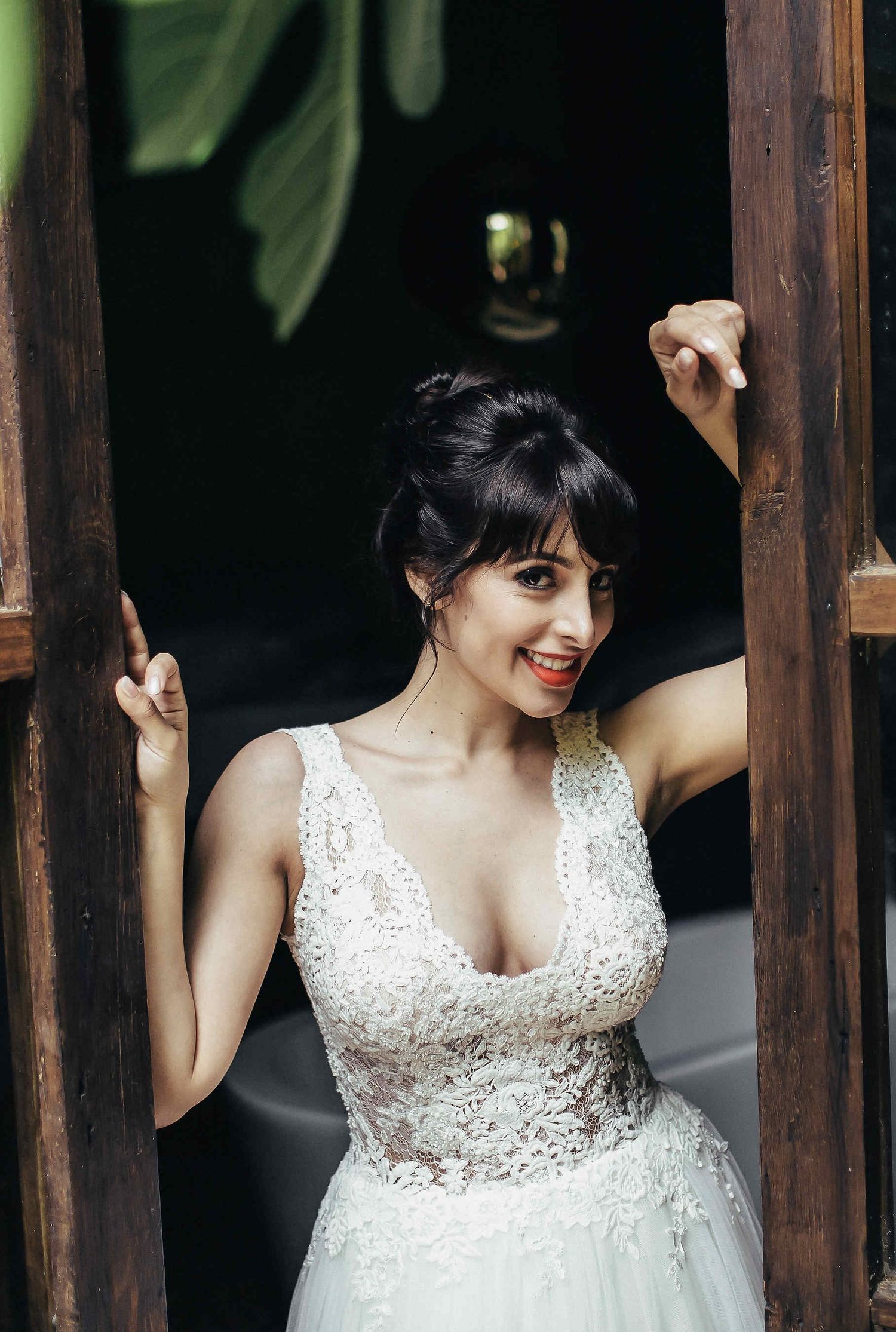 A cinematic portrait of the bride looking out from a window of a historic Spanish villa. Captured by a wedding photographer in Barcelona