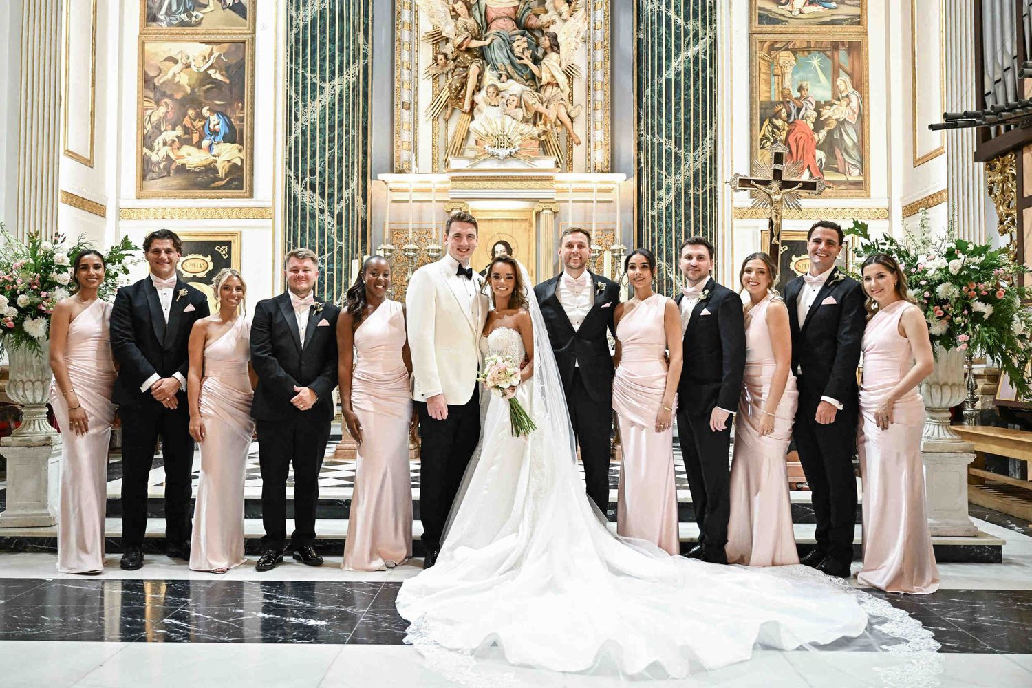 Group photo of the bride and groom with bridesmaids and groomsmen at the altar of a church in Valencia.