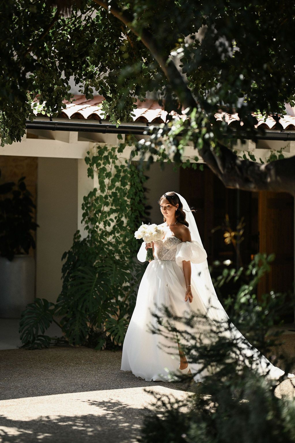 The bride walking towards her groom for their intimate first look reveal in the beautiful historic courtyard of Finca del Canónigo.
