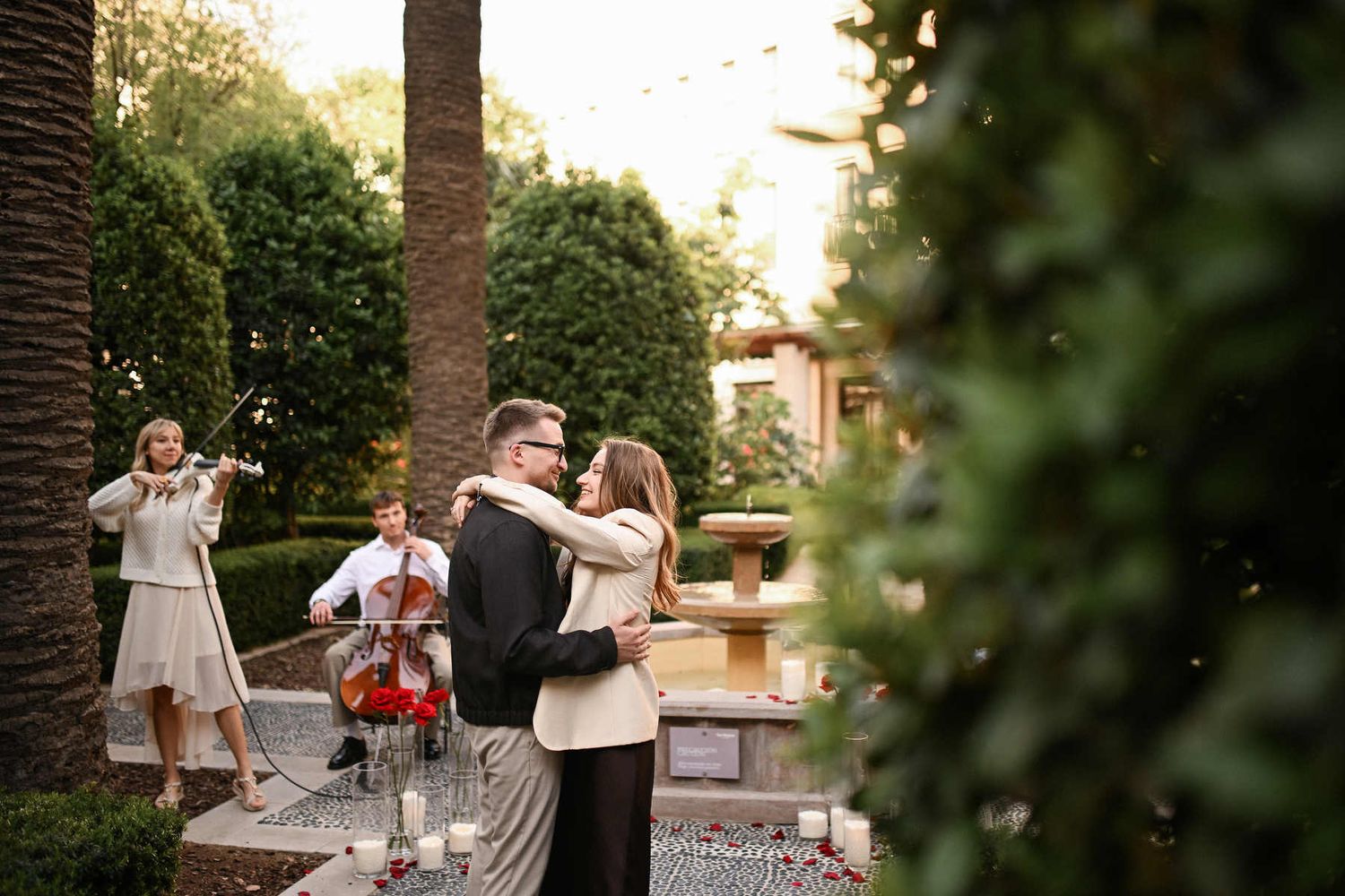 Smiling couple sharing a joyful moment together in The Westin Valencia courtyard right after he popped the question.