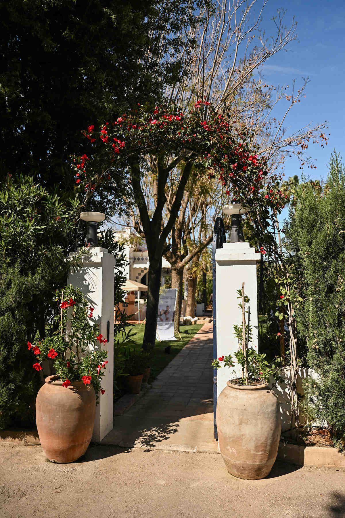 Villa Paula entrance with a lush floral arch and traditional Spanish clay pots. Authentic destination wedding details by Darista