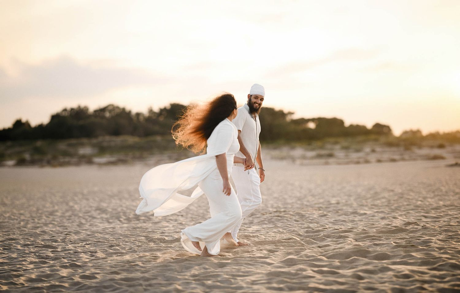 Happy couple running on the sand immediately after a surprise marriage proposal - candid photo and video session on Valencia beach