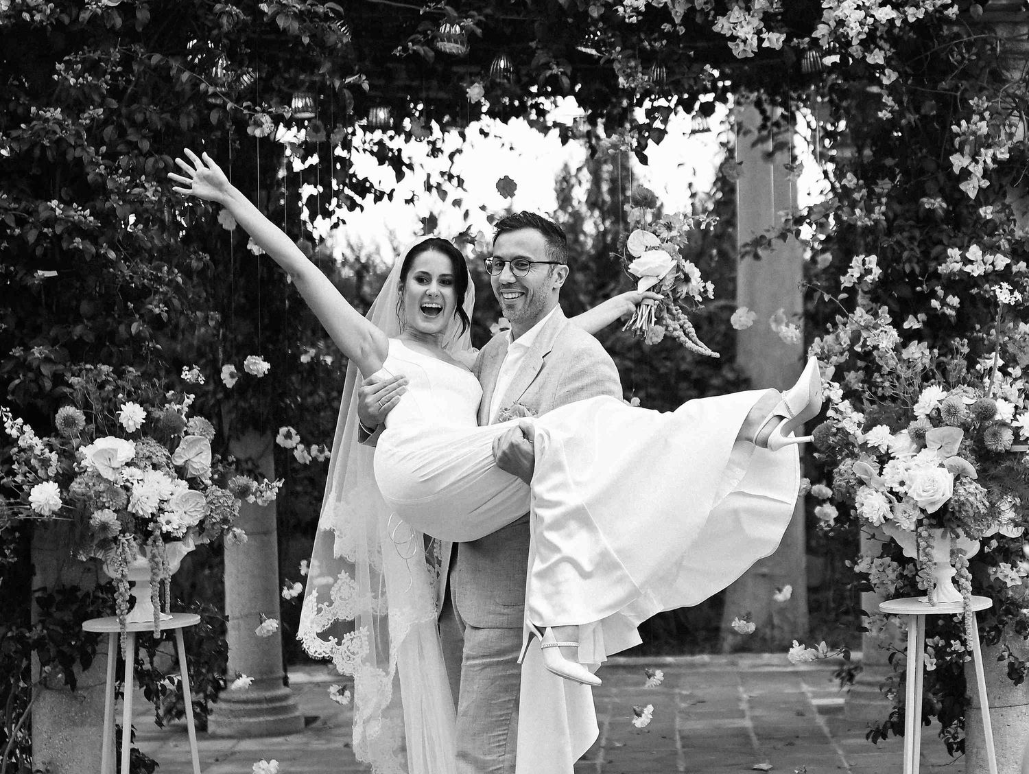 A professional wedding photographer in Valencia captures a joyful moment as the groom lifts his bride during their celebration