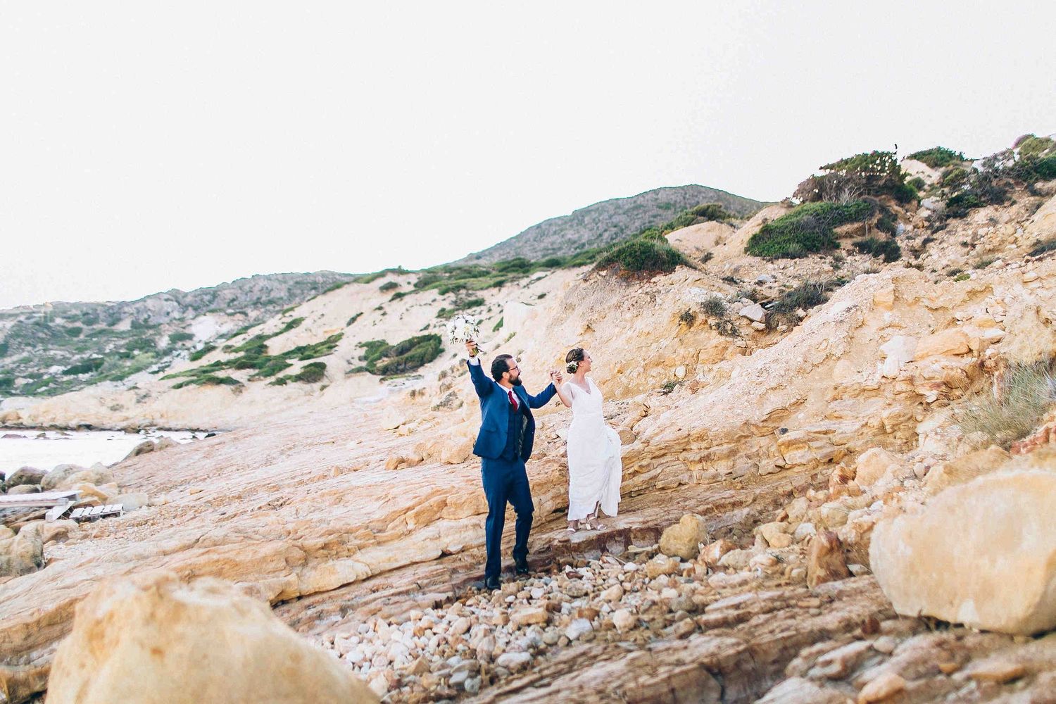 The happy couple waving to their friends and family during the golden hour