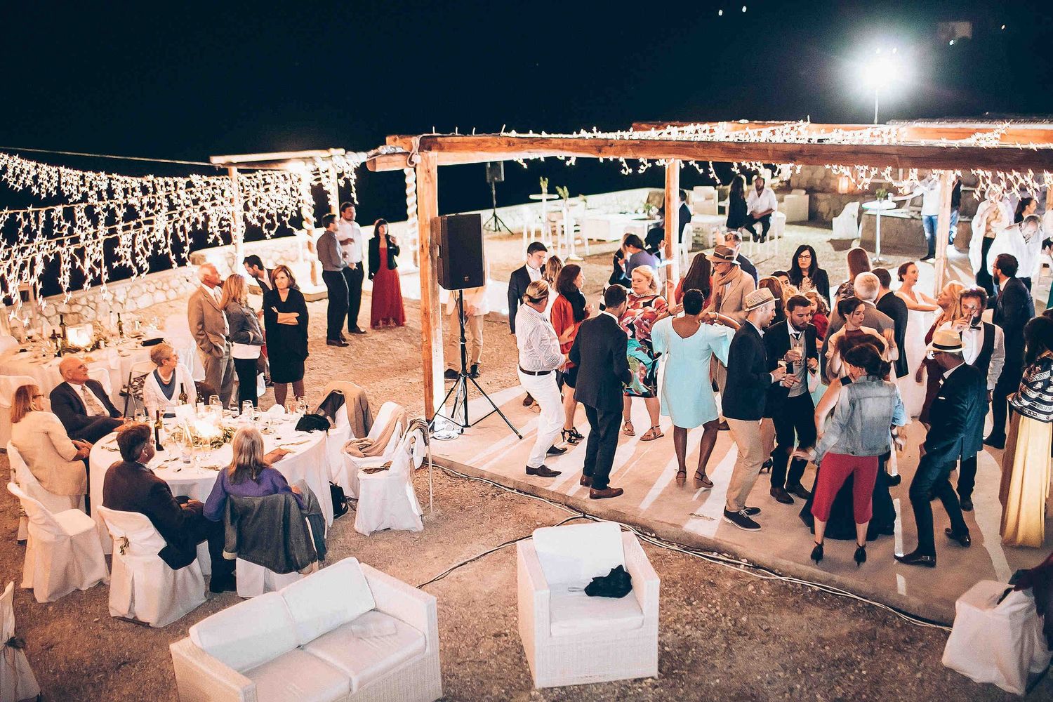 The vibrant and warm atmosphere of a private villa wedding celebration under the Greek stars
