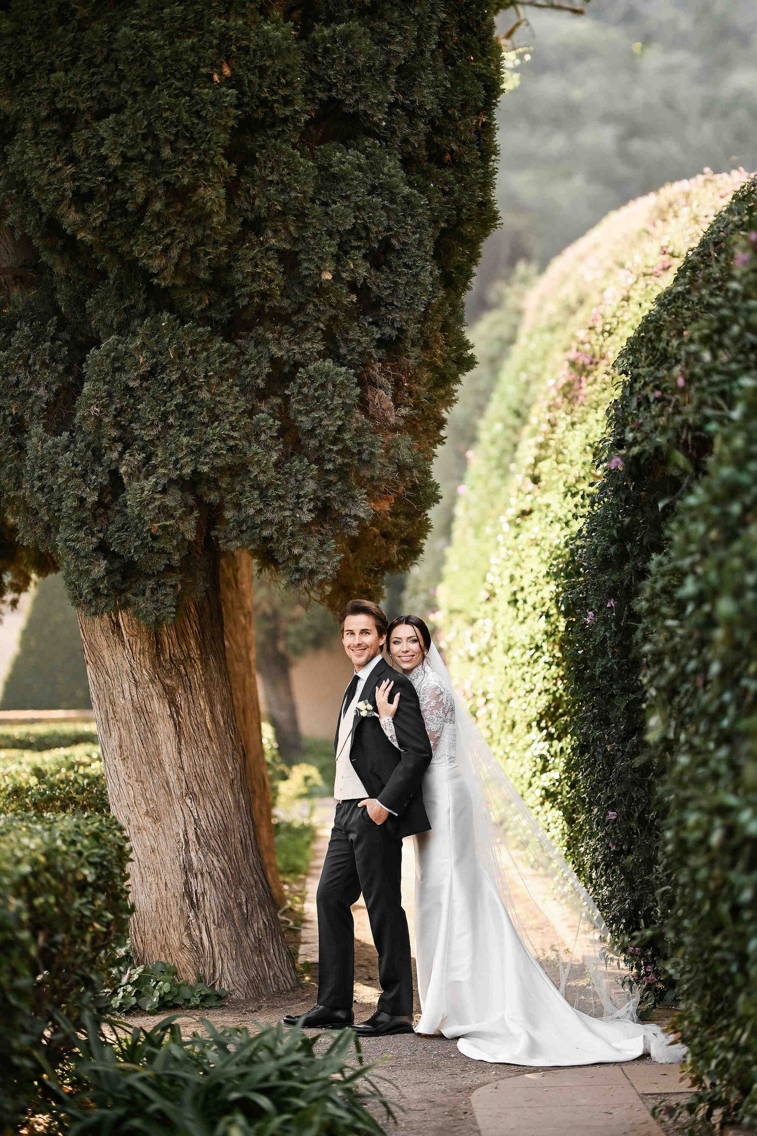 Candid moment of a couple's embrace in the lush greenery of Turia Gardens, captured by a Valencia photographer