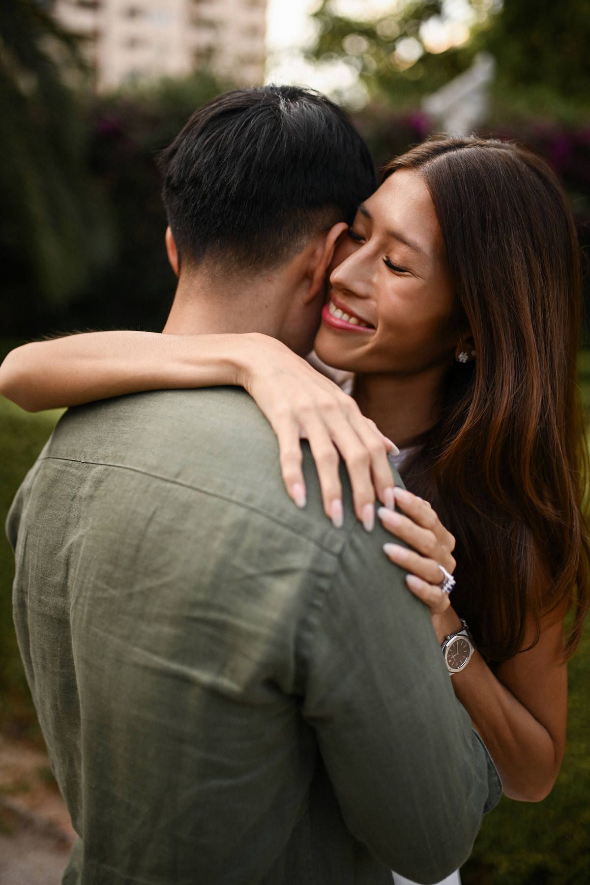Close-up of an engaged woman smiling and hugging her partner, showing off her ring during a romantic photoshoot in Valencia.