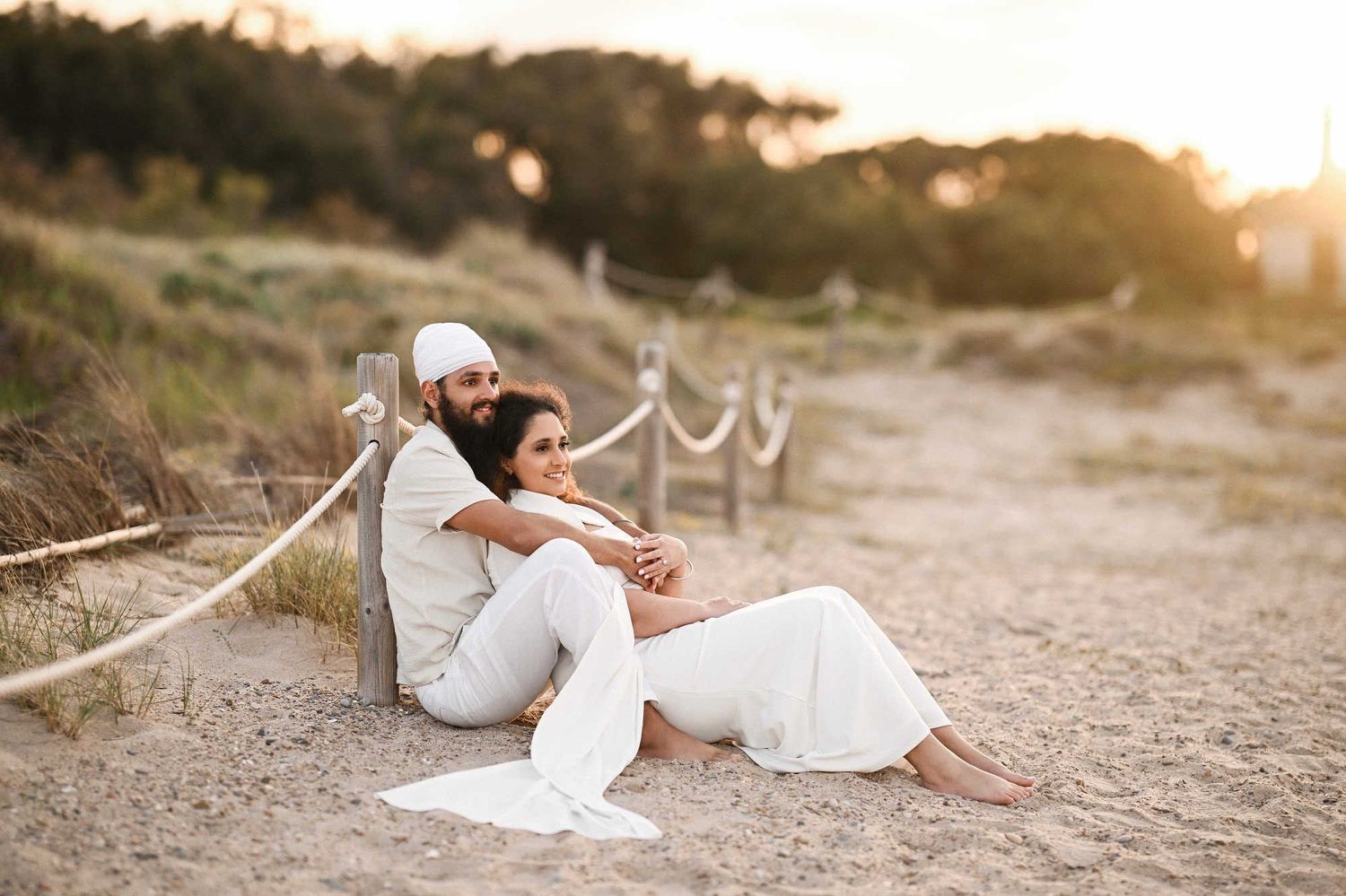 Couple in love sitting and hugging on the beach before a surprise proposal - secret photo and video session in Valencia