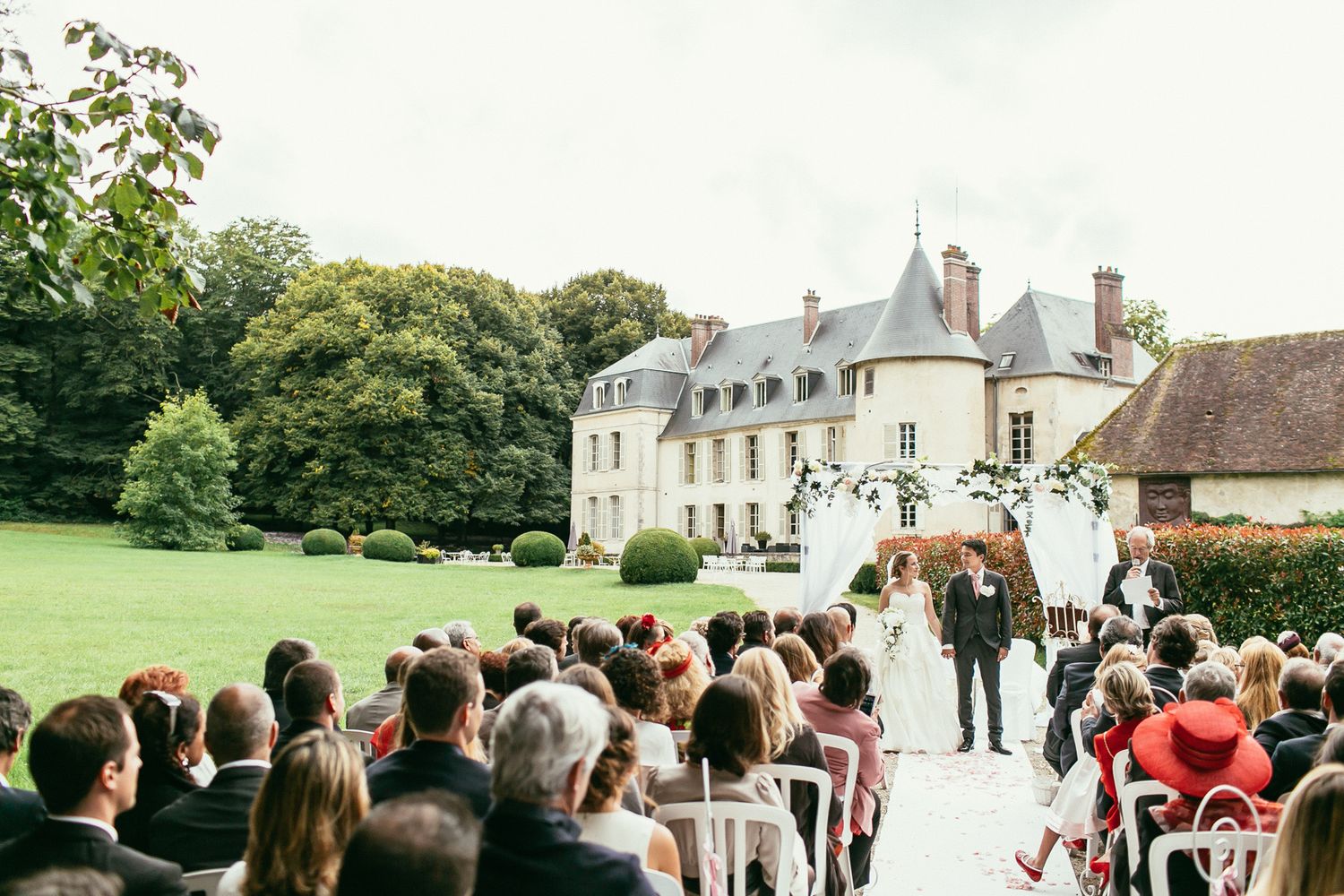 Unscripted emotions at a luxury wedding ceremony. Château de Changy architecture framing a heartfelt, sincere moment