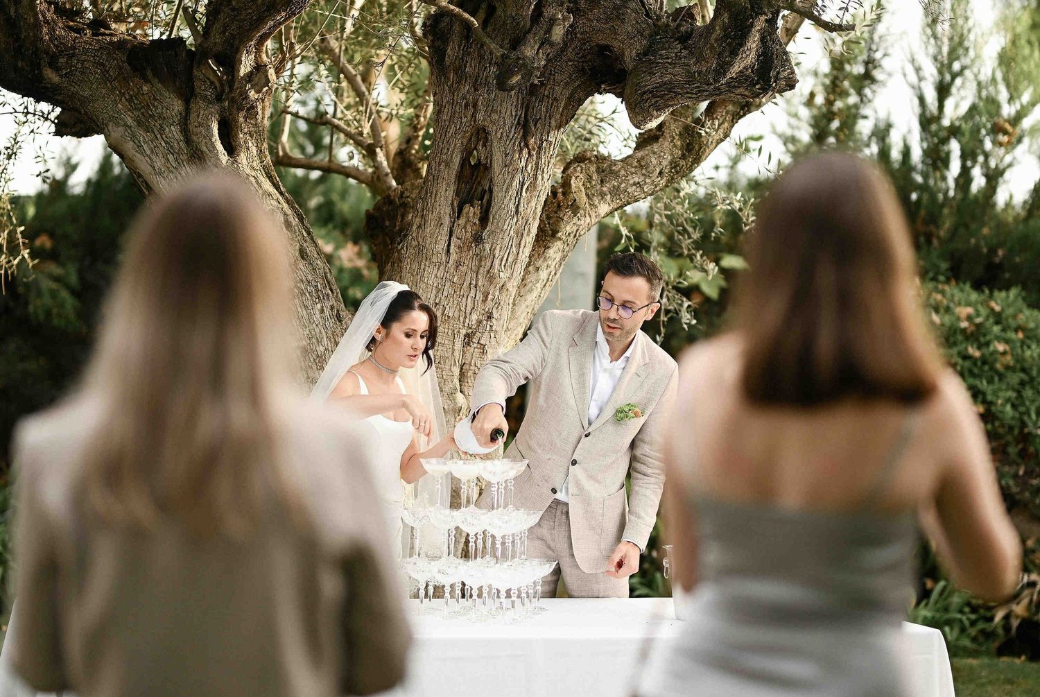 The bride and groom pouring a champagne tower at Villa Paula, capturing a joyful moment with their guests.