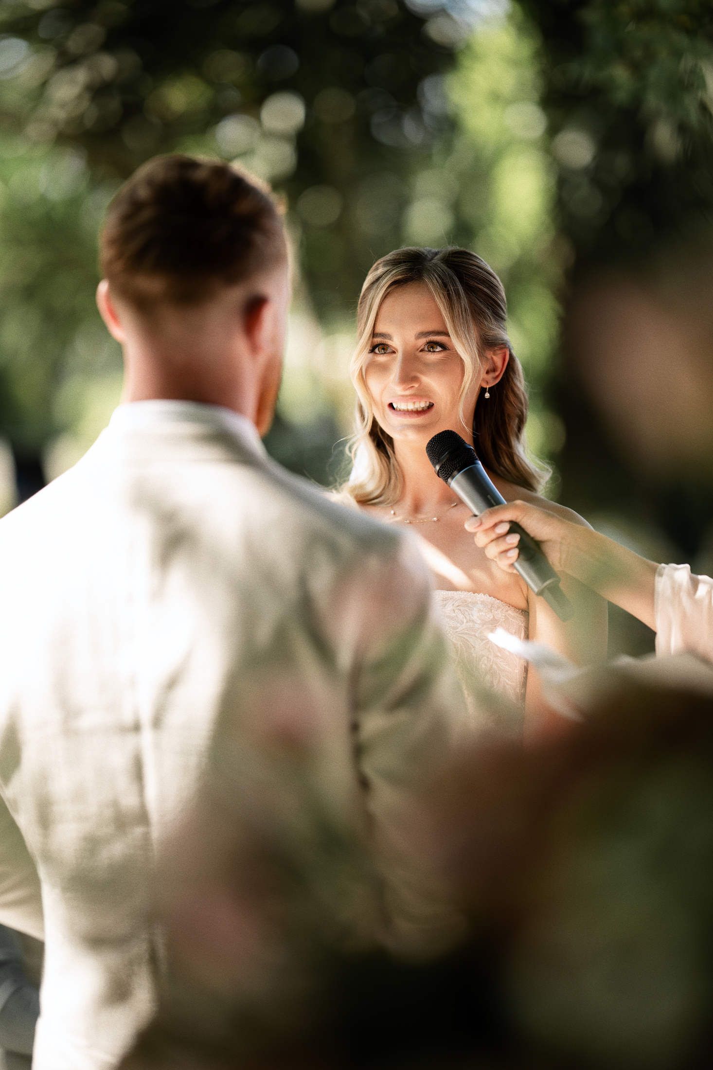 Bride emotional reading her wedding vows to the groom during an outdoor ceremony in the lush gardens of Villa Dela.