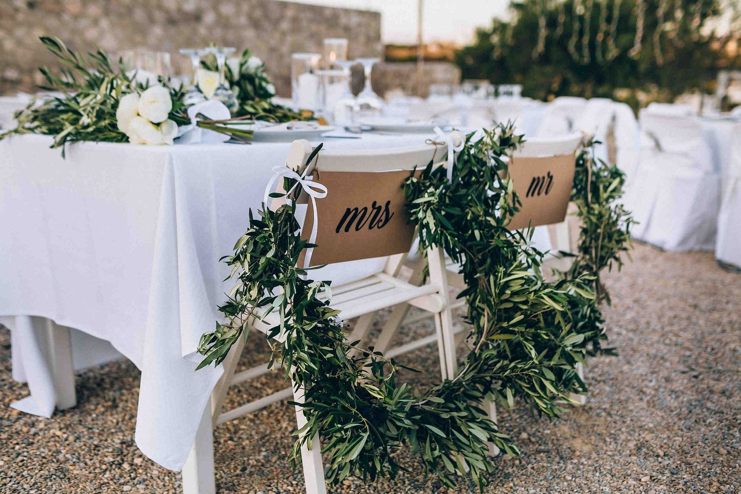 Elegant wedding table decor featuring traditional Greek olive greenery and minimalist styling