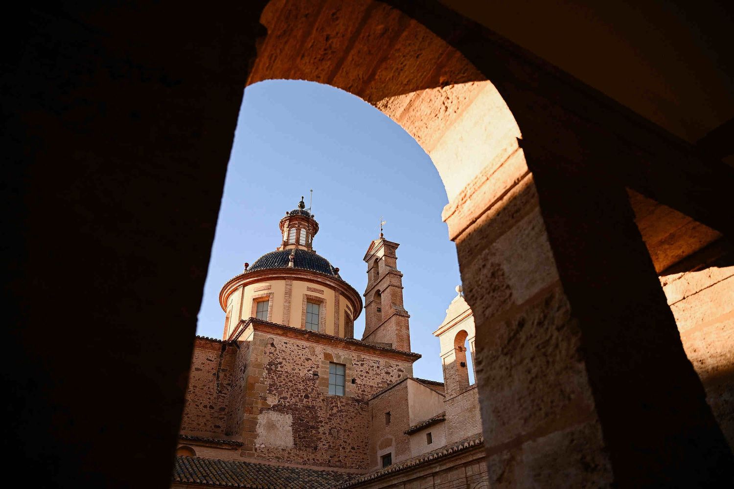 Architectural view of the historic towers at La Cartoixa d'Ara Christi, a luxury wedding venue in Valencia, Spain.