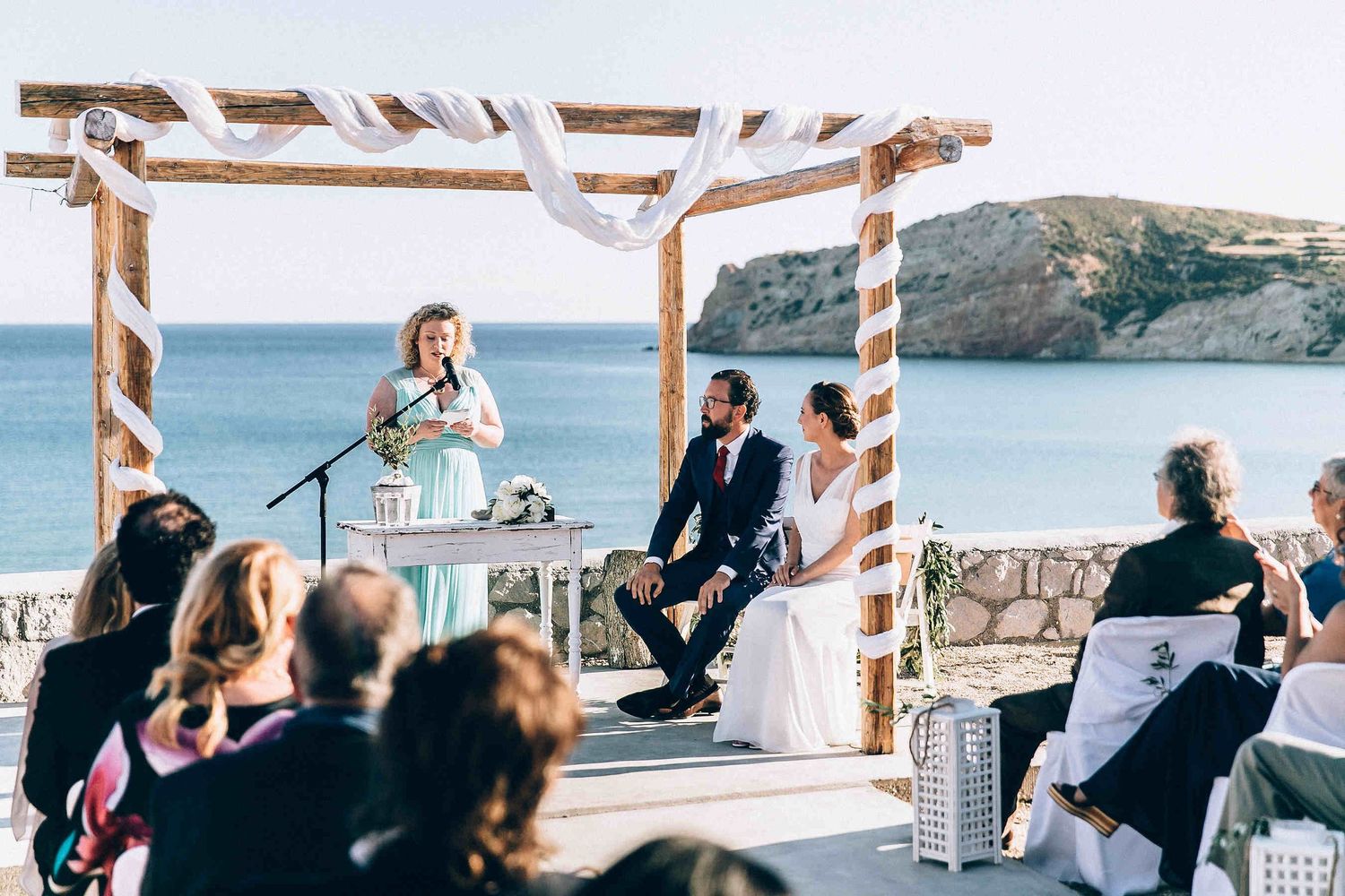 Intimate wedding ceremony held at the edge of the cliffs with the deep blue sea of Milos