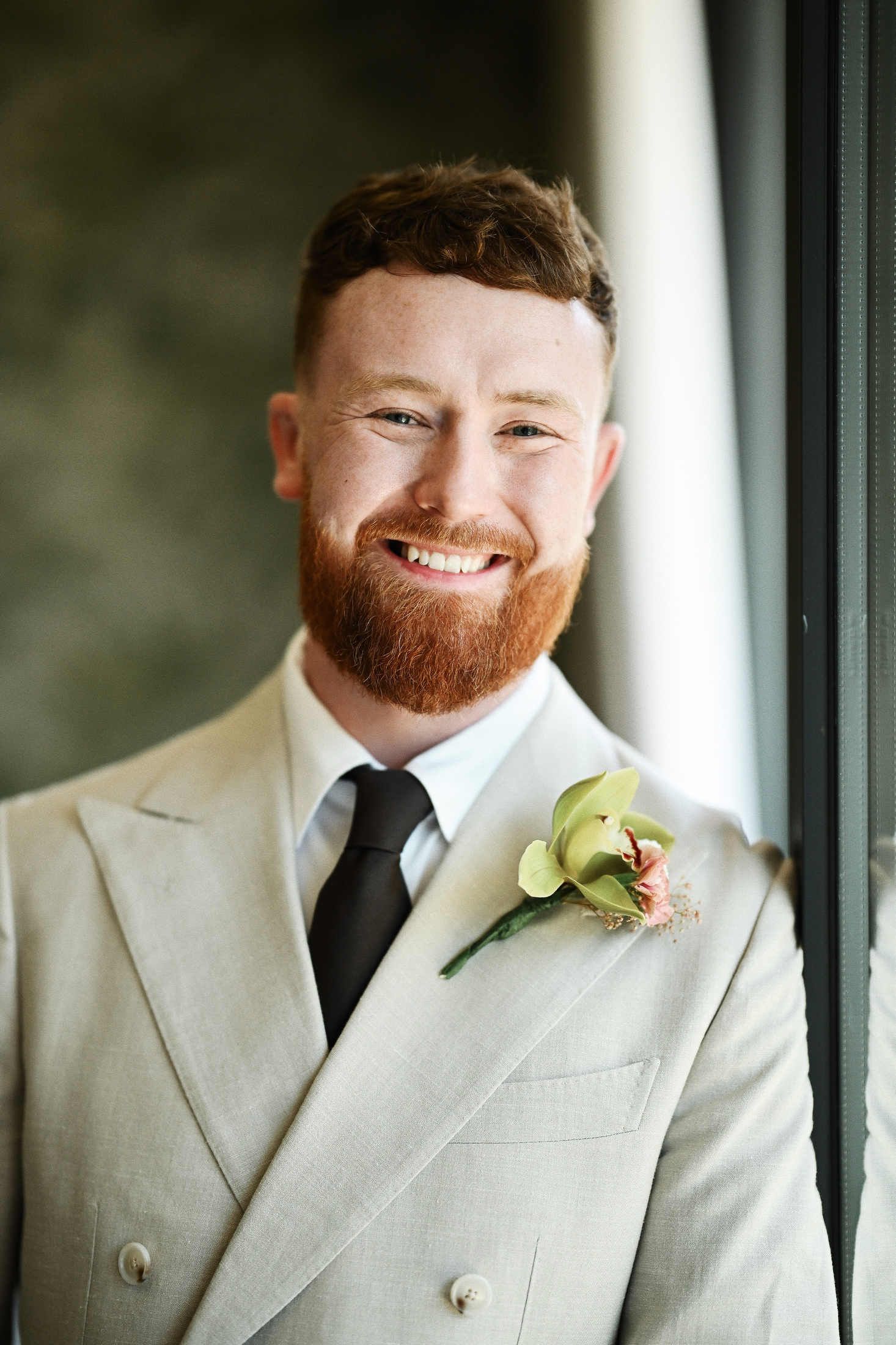 Elegant close-up portrait of the groom wearing a stylish floral boutonniere on his suit jacket at Villa Dela Valencia.
