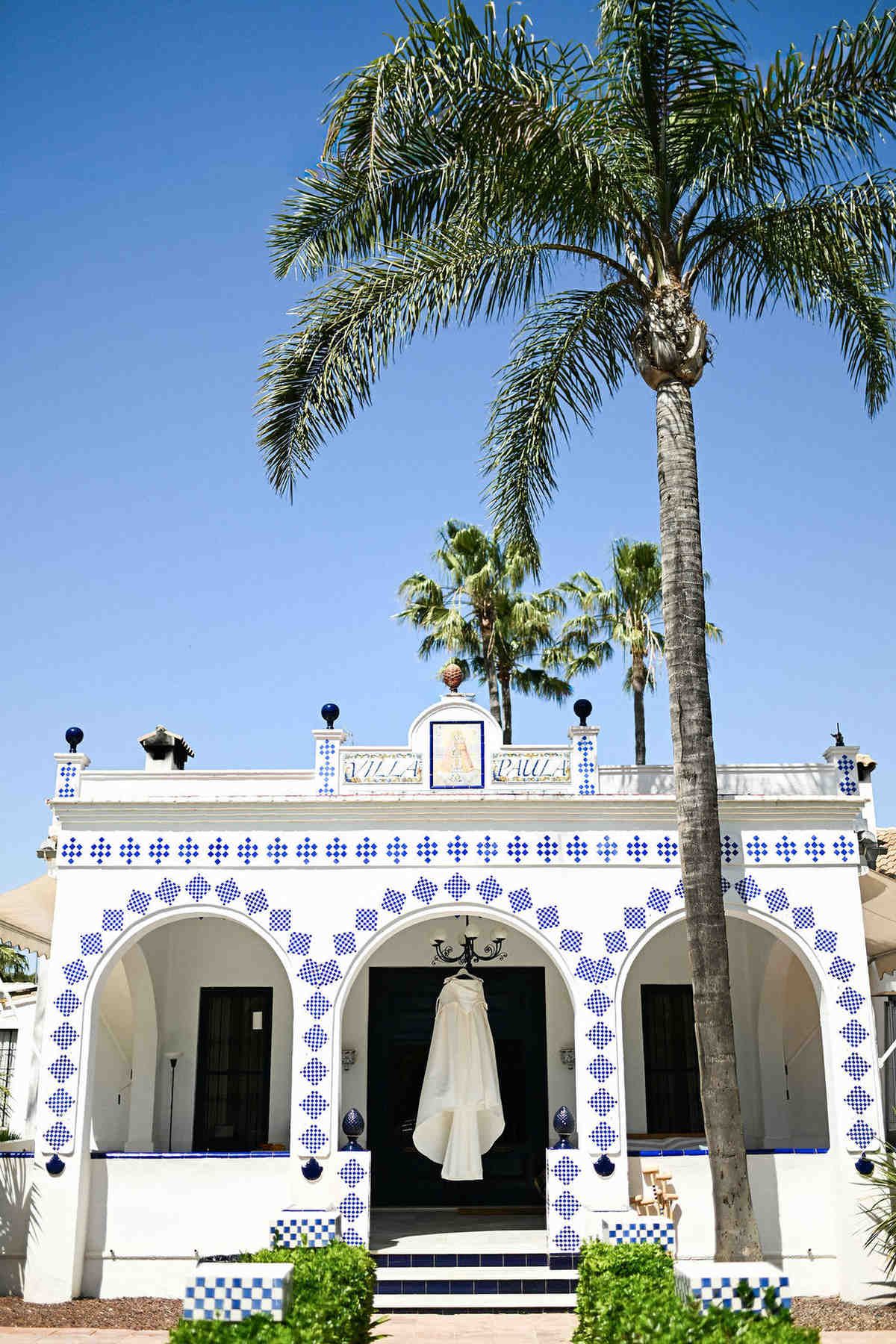 Iconic white facade of Villa Paula accented with signature blue tiles. Editorial architecture wedding portrait by Darista team