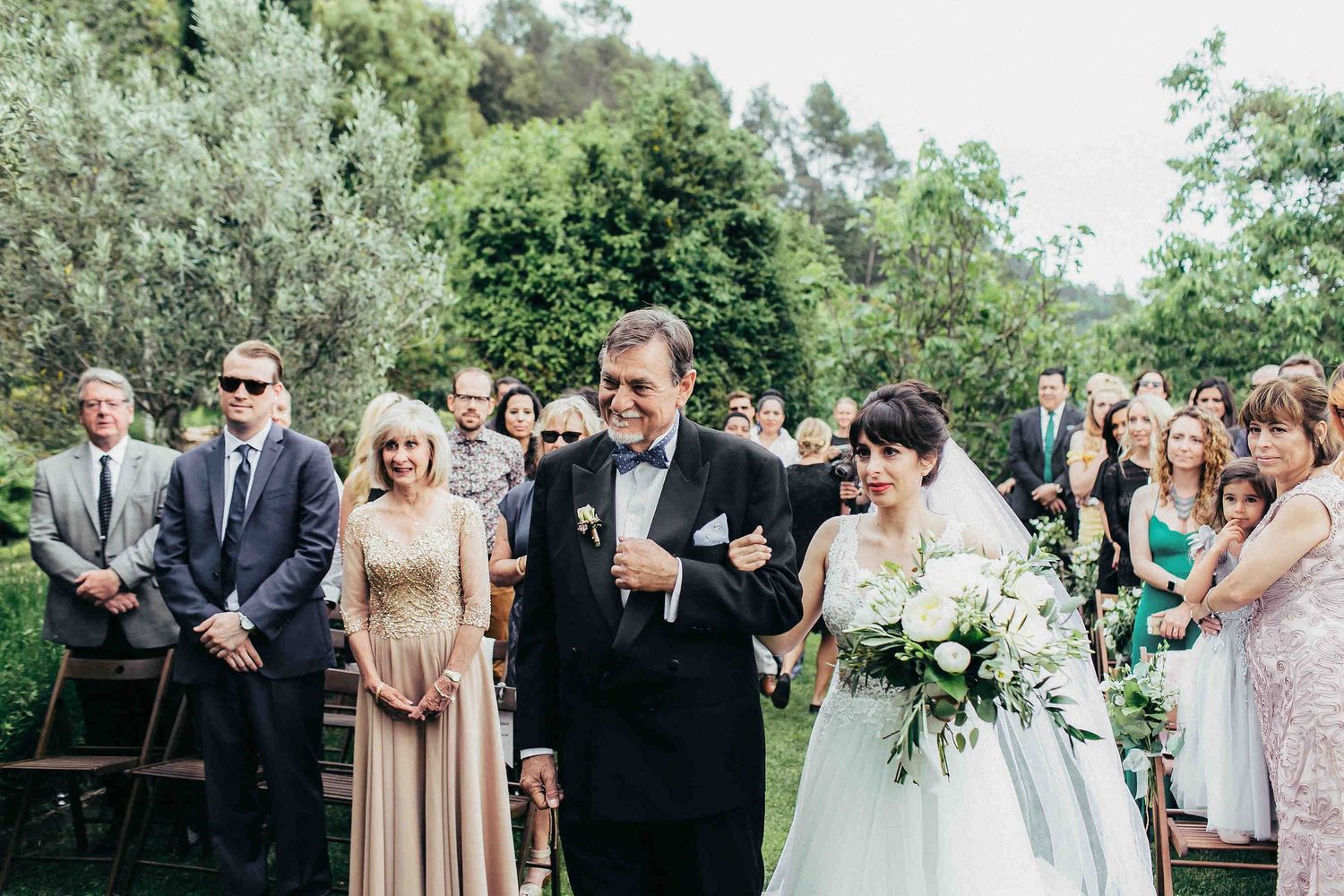 A traditional moment of the father walking the bride down the aisle at a historic villa near Barcelona. Authentic Spanish wedding story.