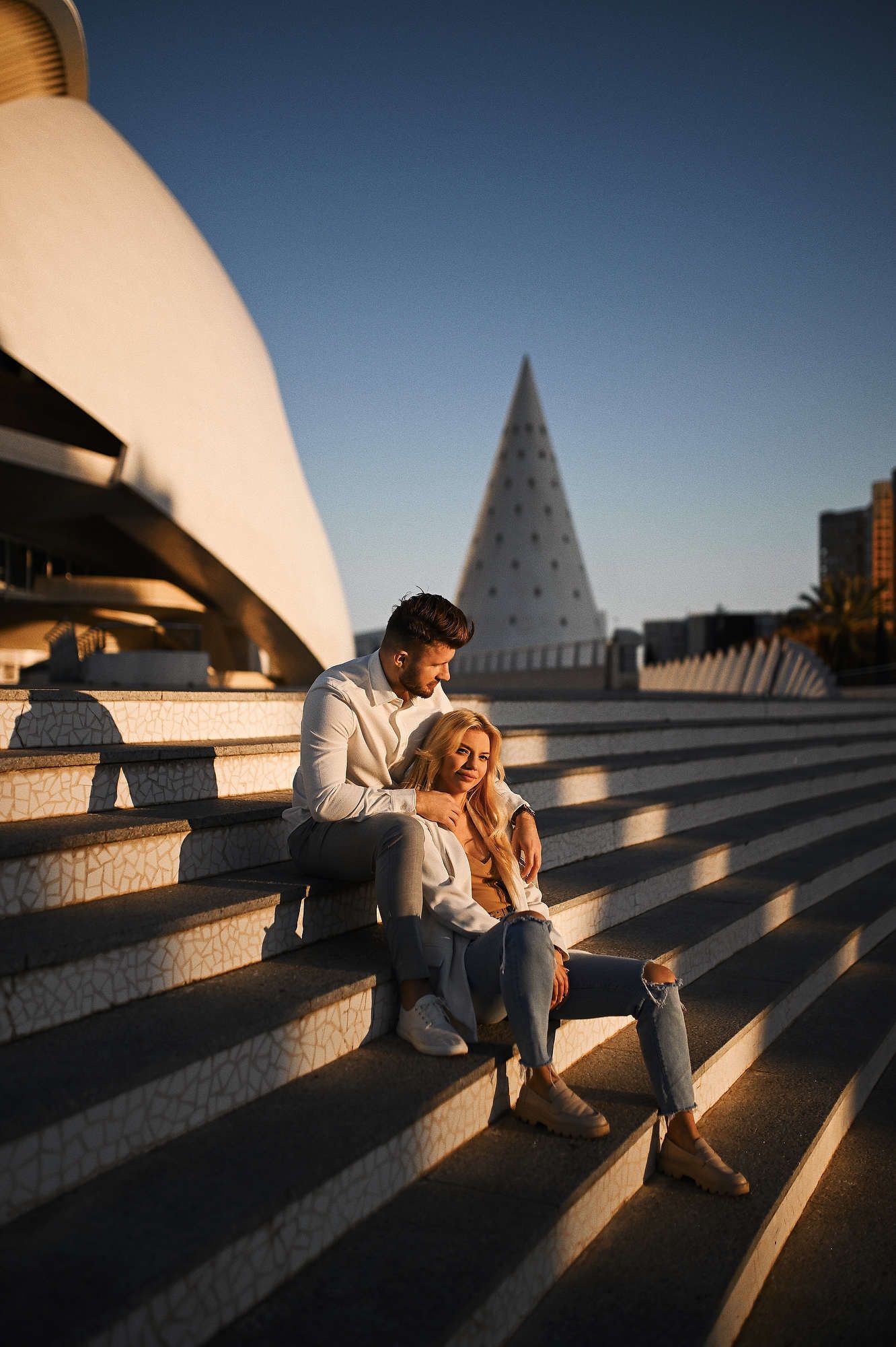 High-end editorial photography in Valencia featuring a couple walking past the Hemisferic building.