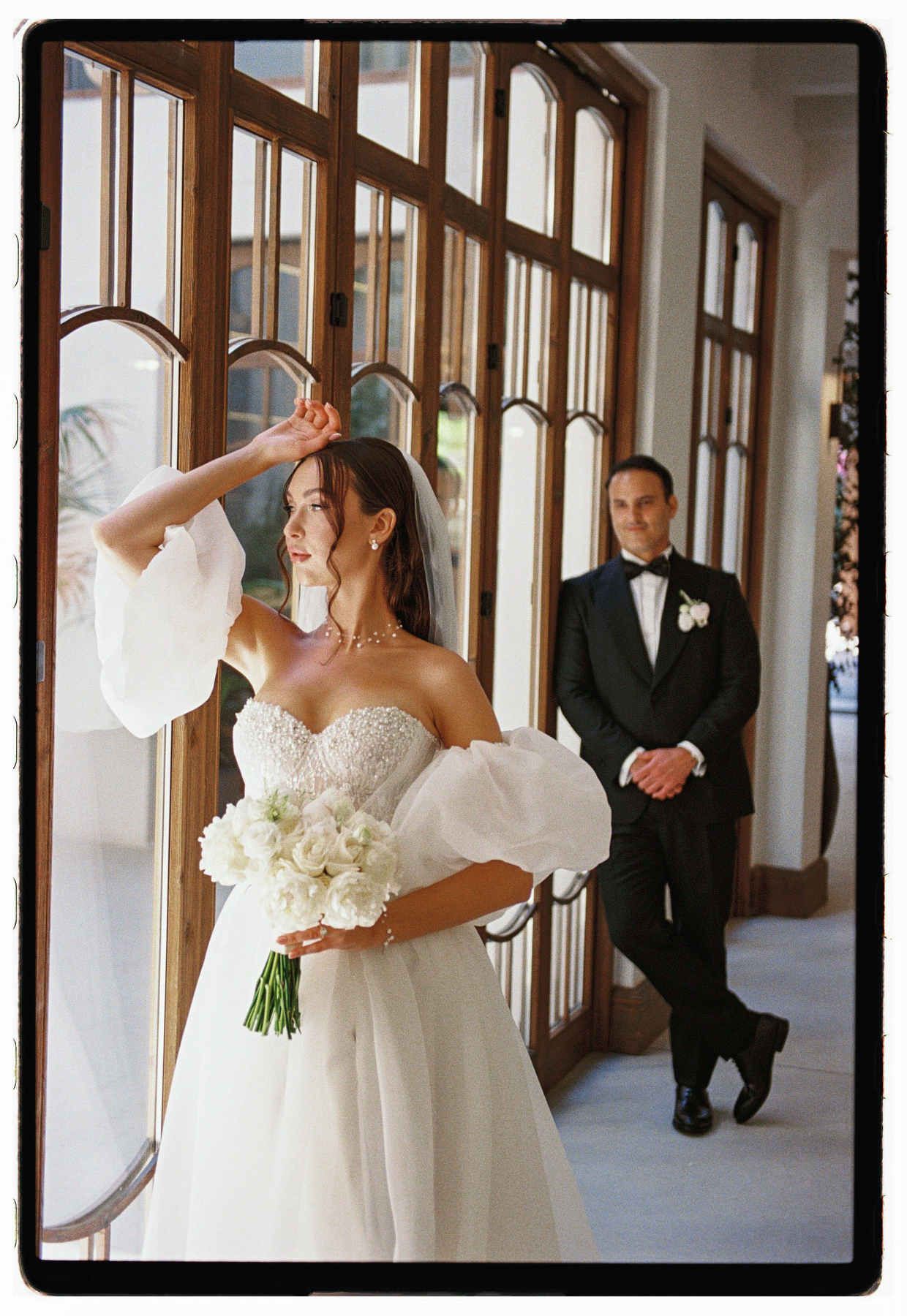 Editorial bride portrait on Kodak Portra in Valencia, groom watching in the background, film wedding photography.