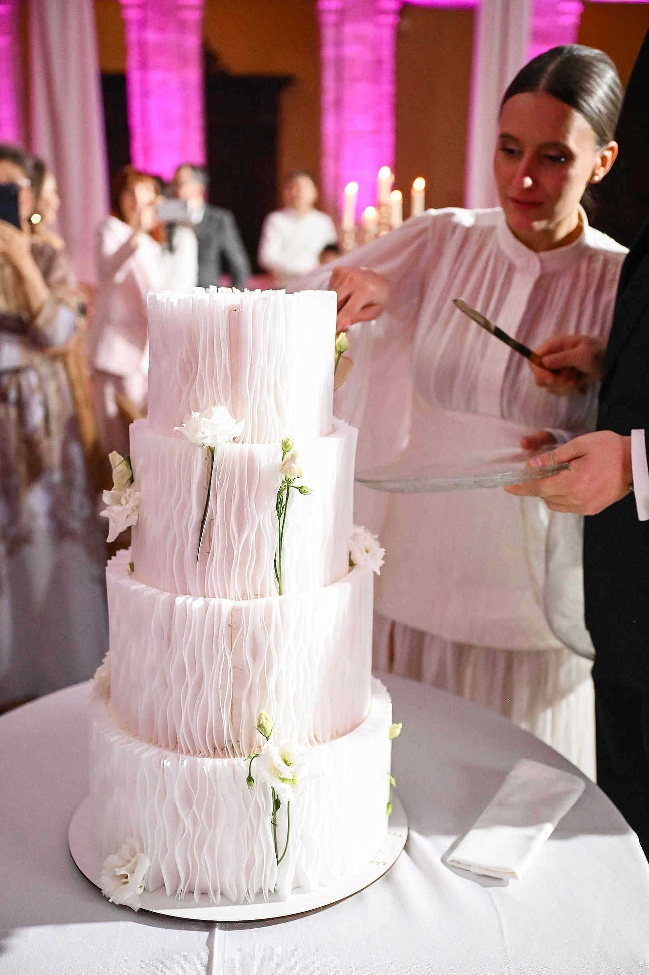 Happy bride and groom cutting their wedding cake during the reception at La Cartoixa d'Ara Christi, Valencia.