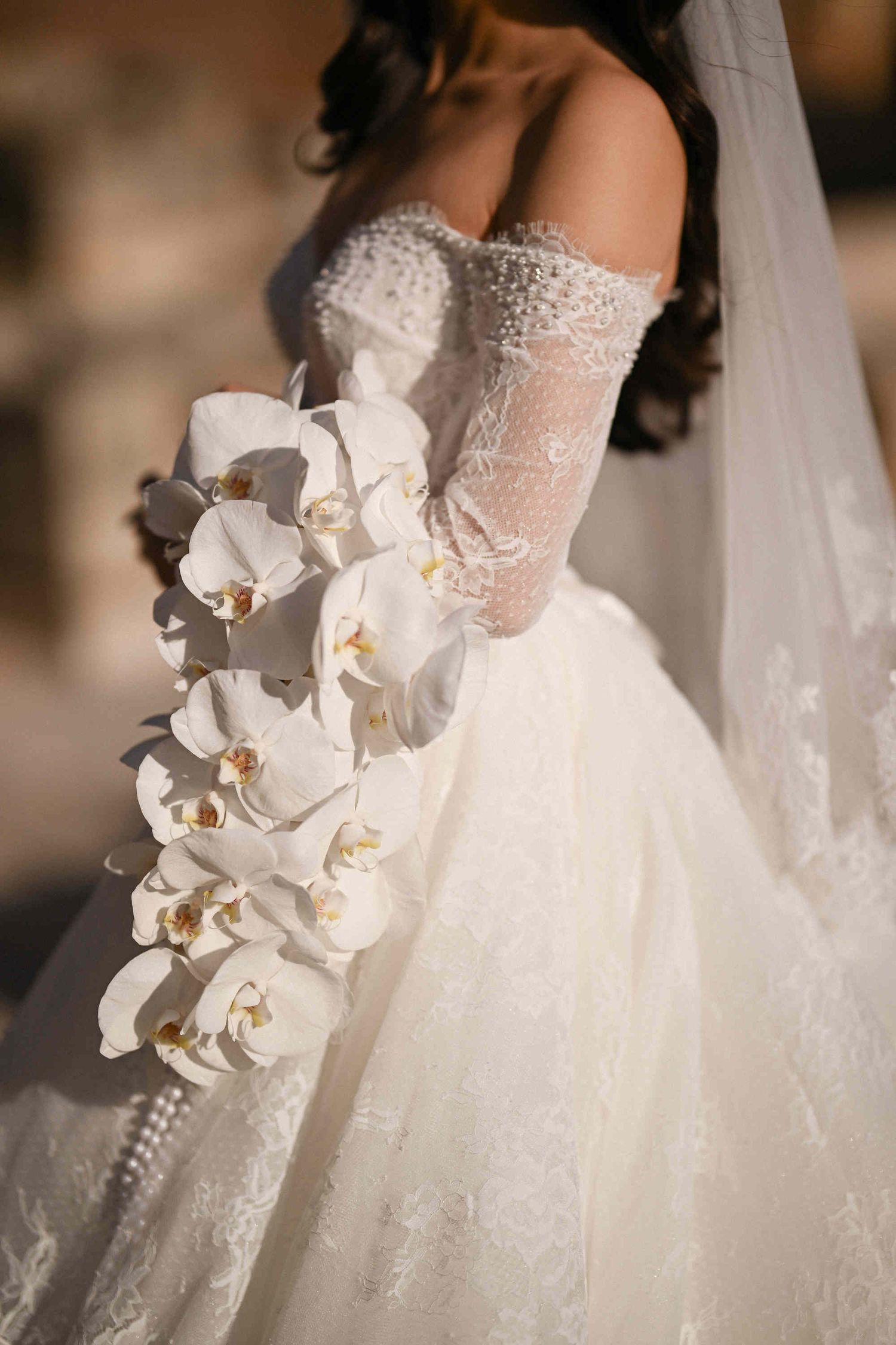 Detailed close-up of a luxury white orchid wedding bouquet at Monasterio de Santa María de la Valldigna, Valencia, Spain.
