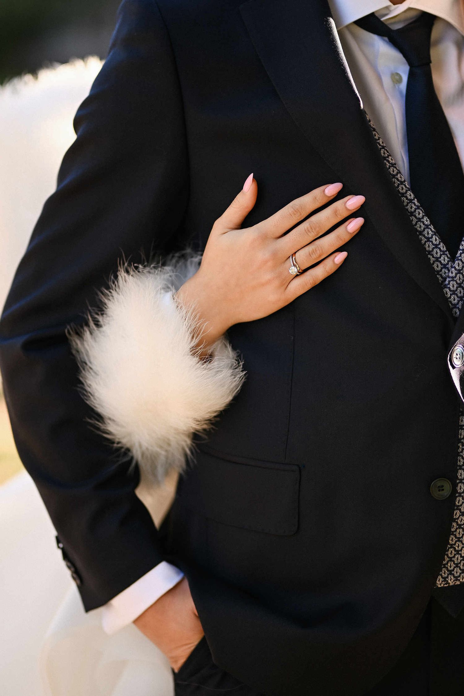 Close-up of the bride's hand with an engagement ring embracing the groom, a tender 
