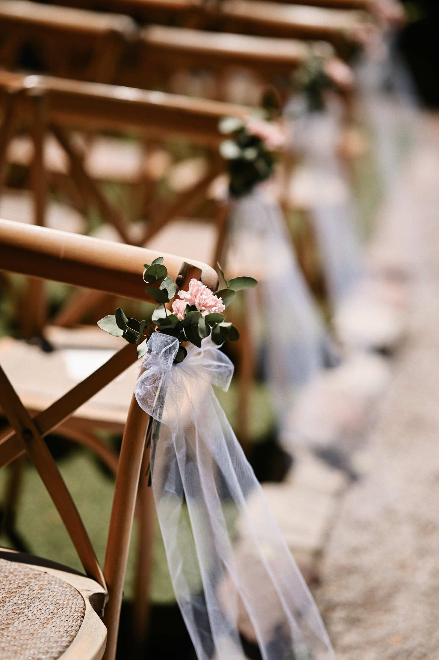 Elegant wedding ceremony guest chairs decorated with fresh blooming flowers at Villa Dela luxury destination venue.