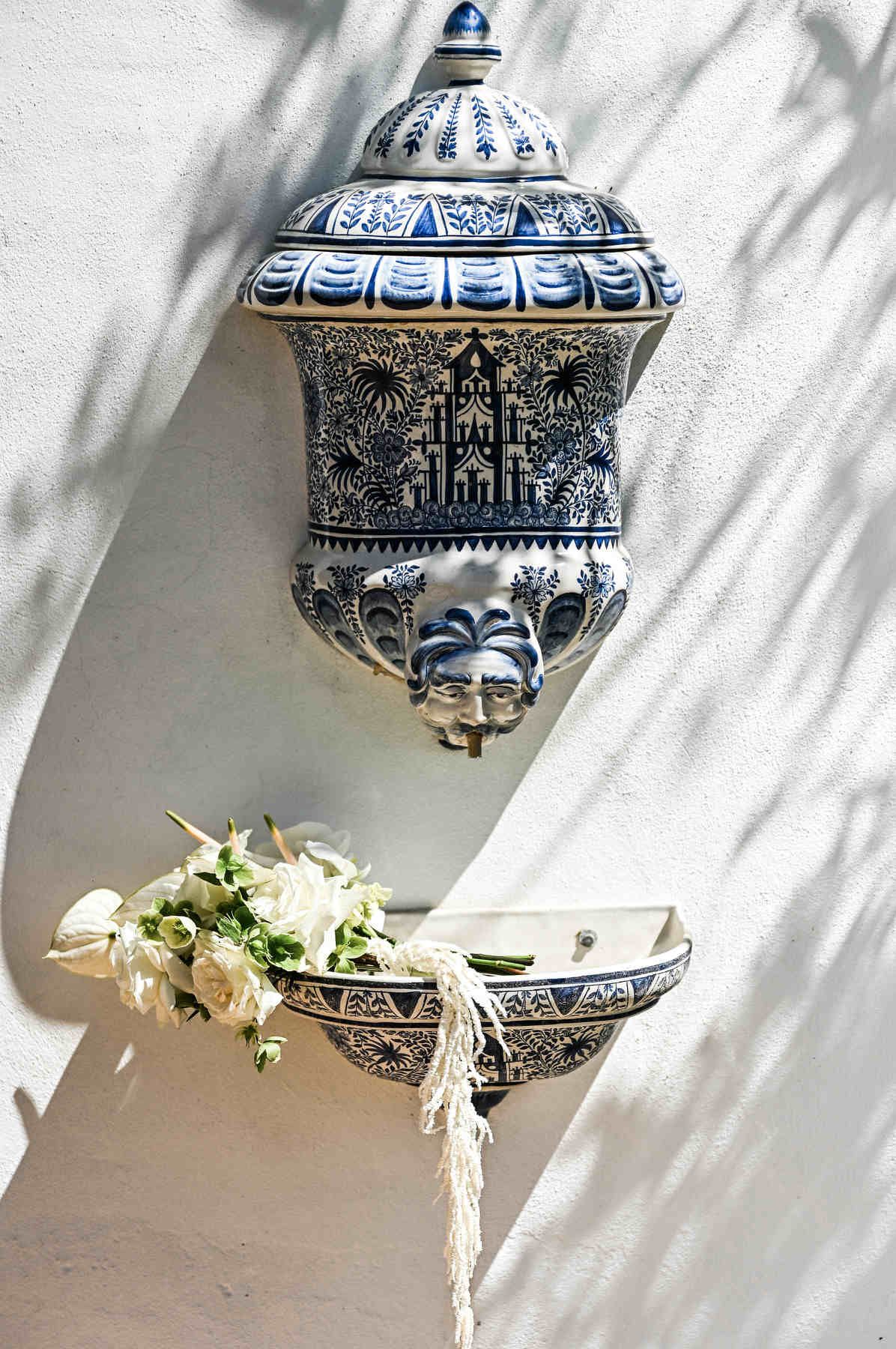 Bridal bouquet resting on an antique stone fountain at Villa Paula. Fine art wedding details captured by Darista photography