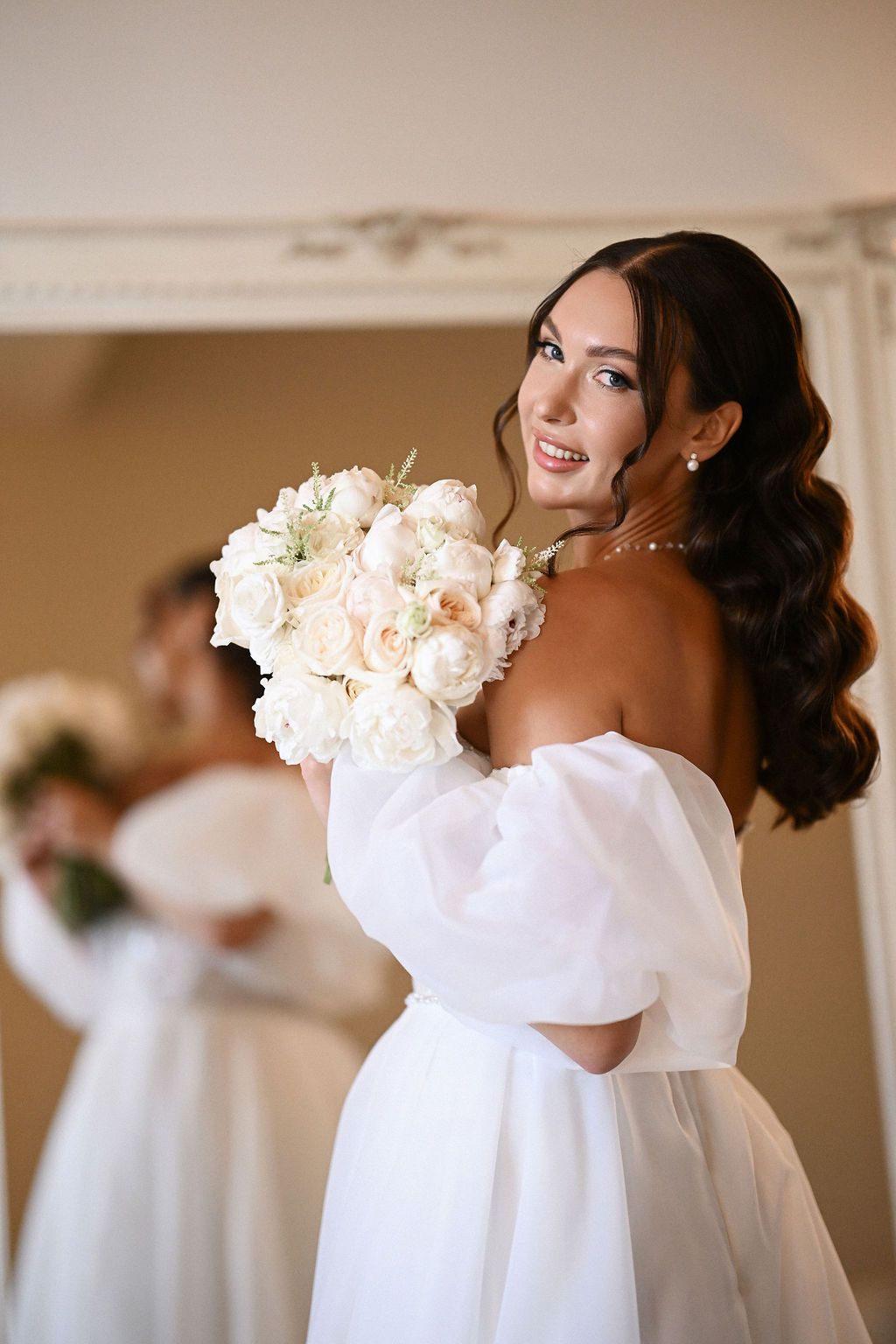 Stunning portrait of the bride in her wedding dress holding a bouquet and looking into the camera. Fine art photography by Darista.