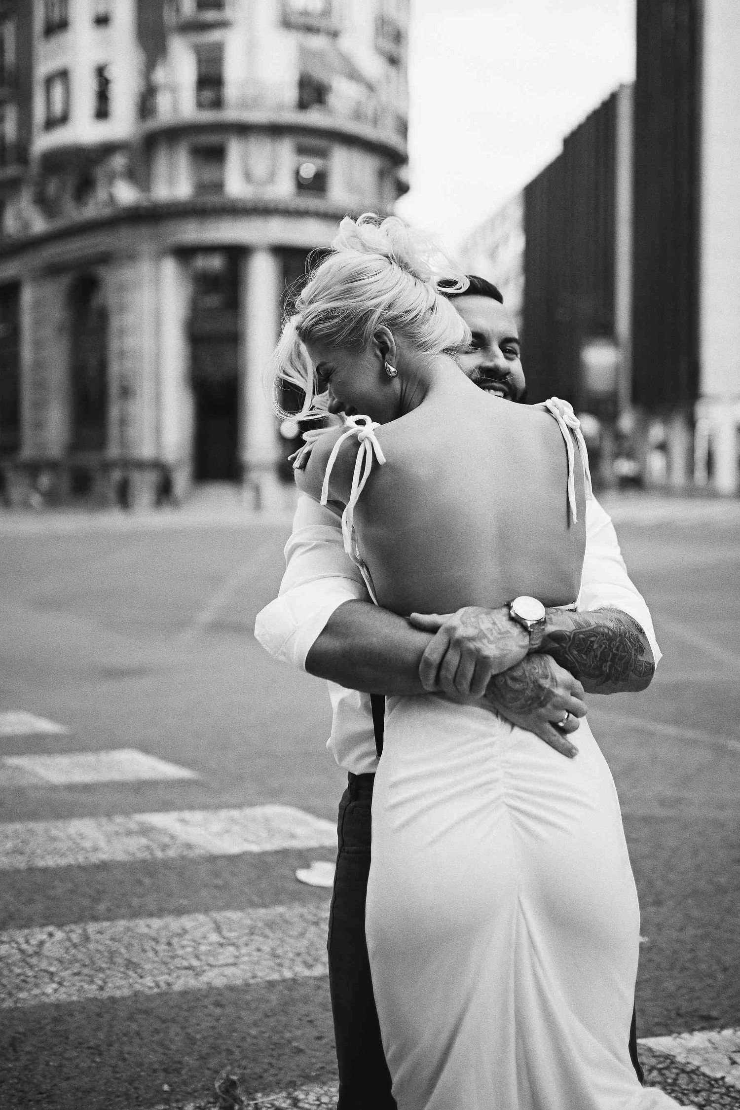 Black and white documentary photography of the groom spinning the bride. Raw, joyful emotions in the historic center of Valencia