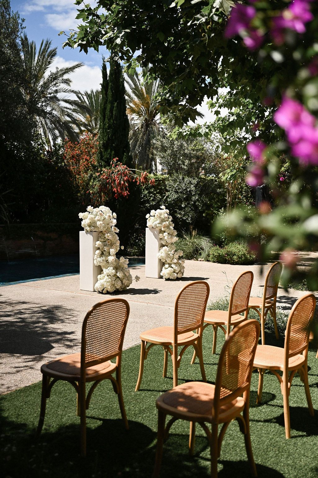Elegant guest seating and a magnificent arch made of fresh live flowers at the outdoor wedding ceremony site of Finca del Canónigo.