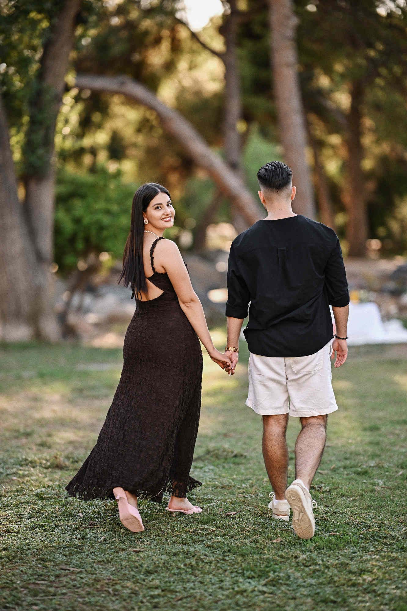 Happy couple walking hand in hand through Viveros Park right after their secret marriage proposal.