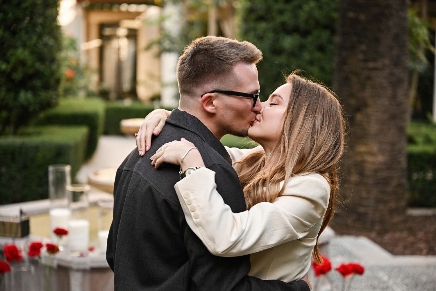 A romantic close-up kiss after a surprise wedding proposal in the lush Mediterranean gardens of Valencia.