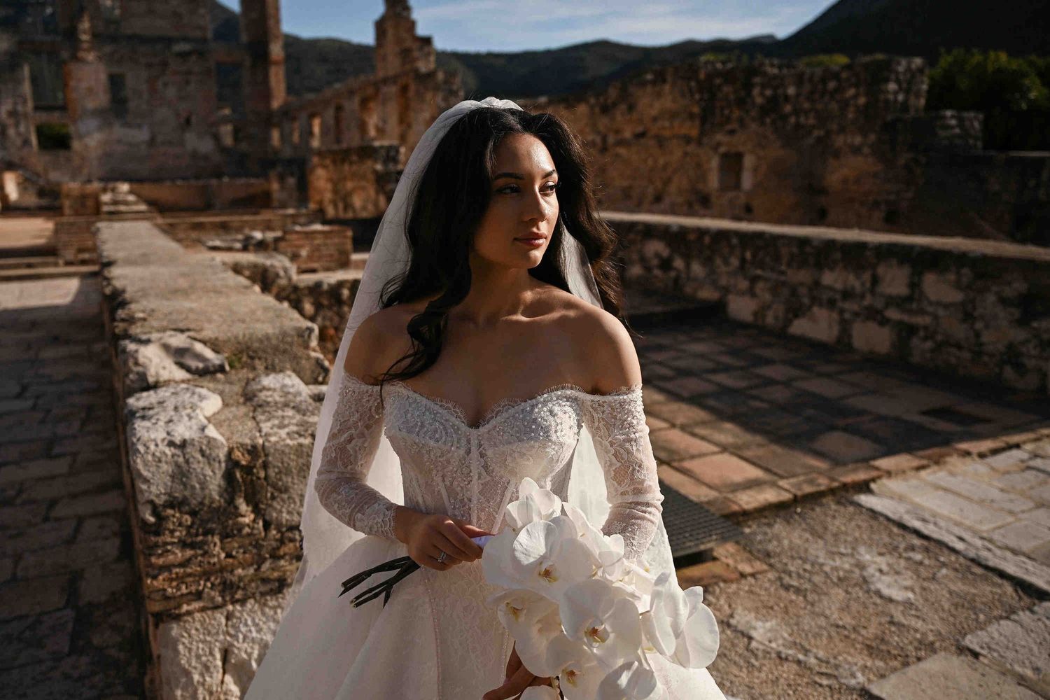 Bridal portrait with a flowing veil in the historic courtyard of Monasterio de Santa María de la Valldigna, Spain.