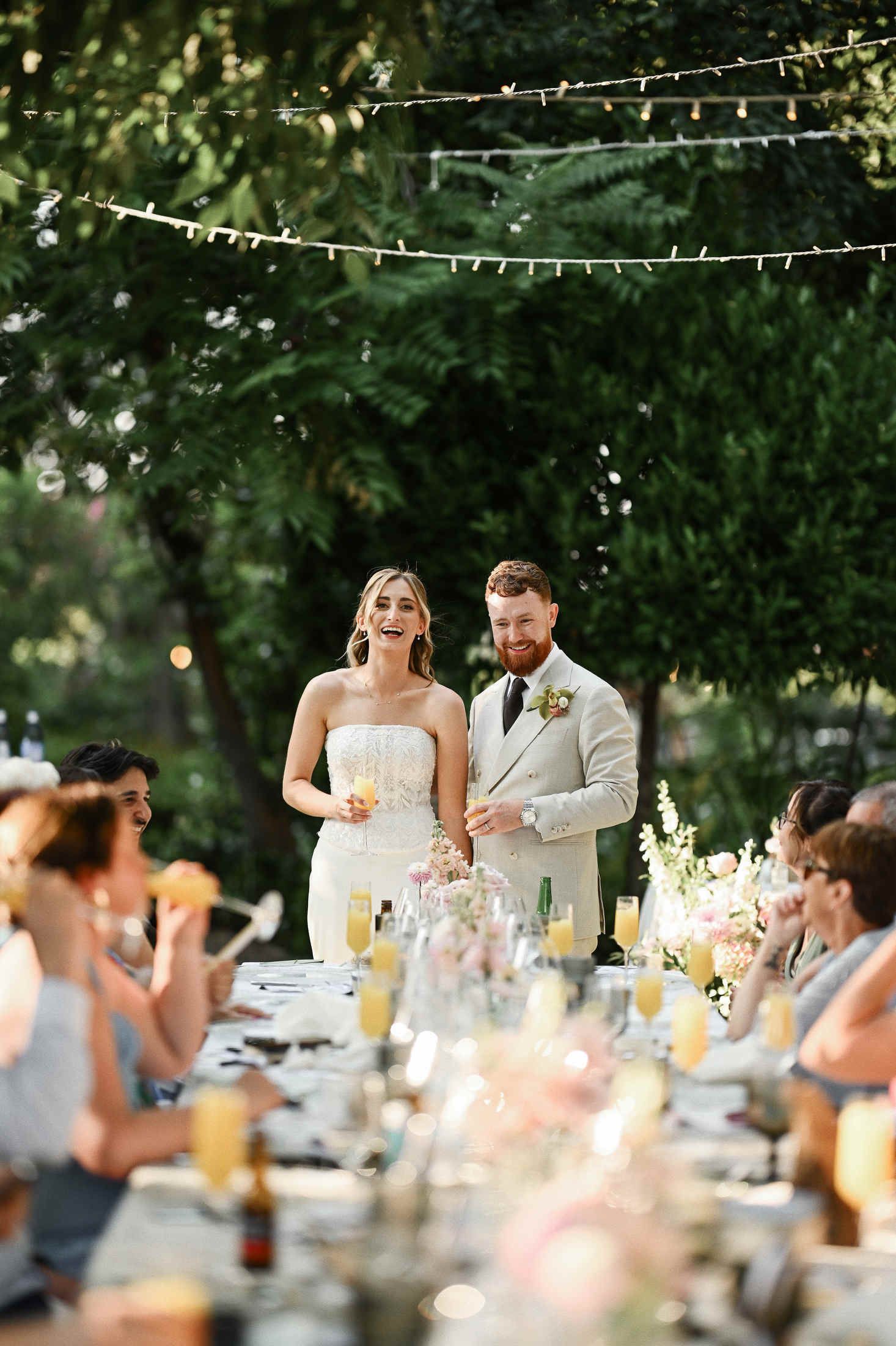 Bride and groom giving a welcome speech to guests during an outdoor wedding reception dinner in the Villa Dela gardens.